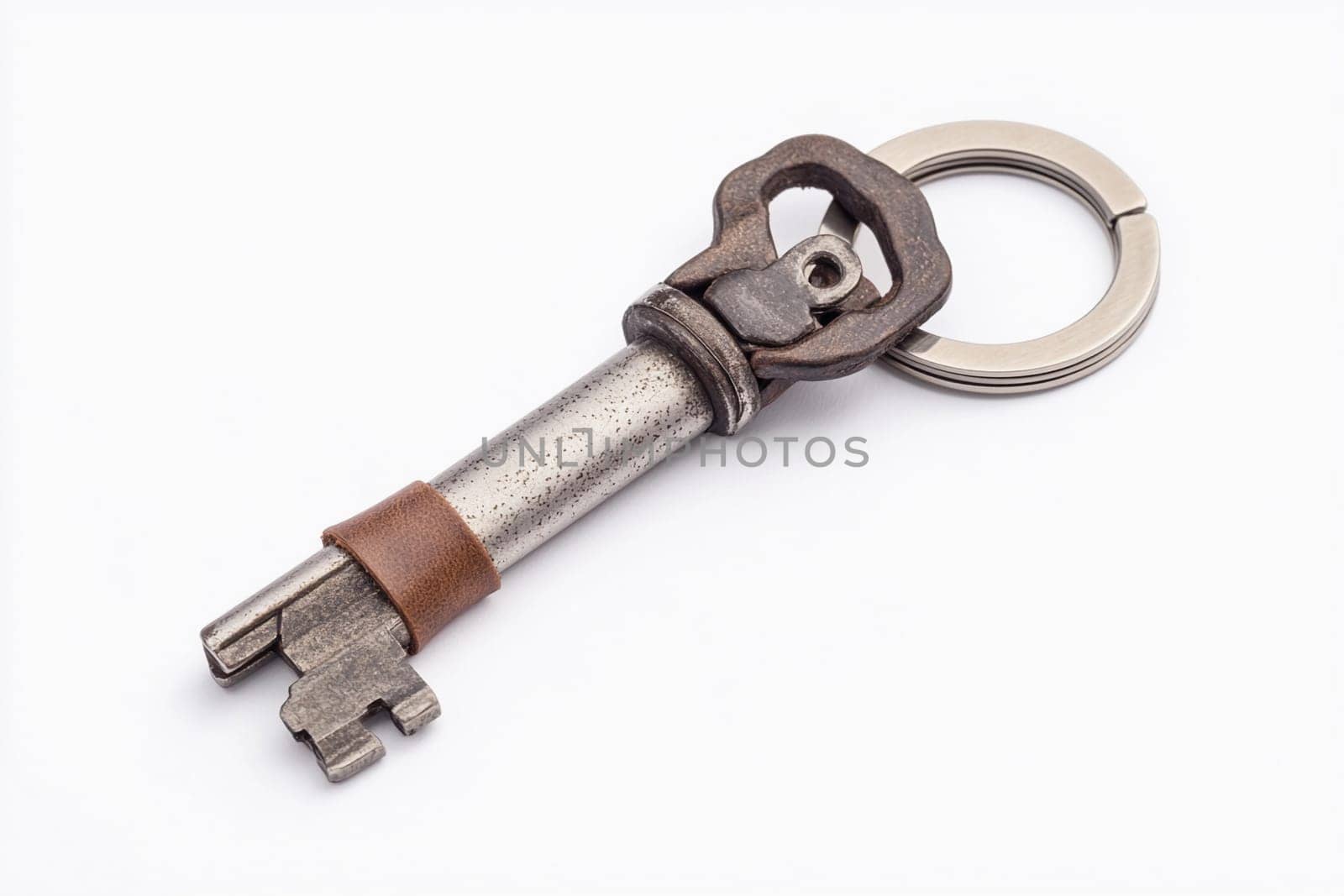 A vintage metal key attached to a key ring with a leather strap in a close-up view.