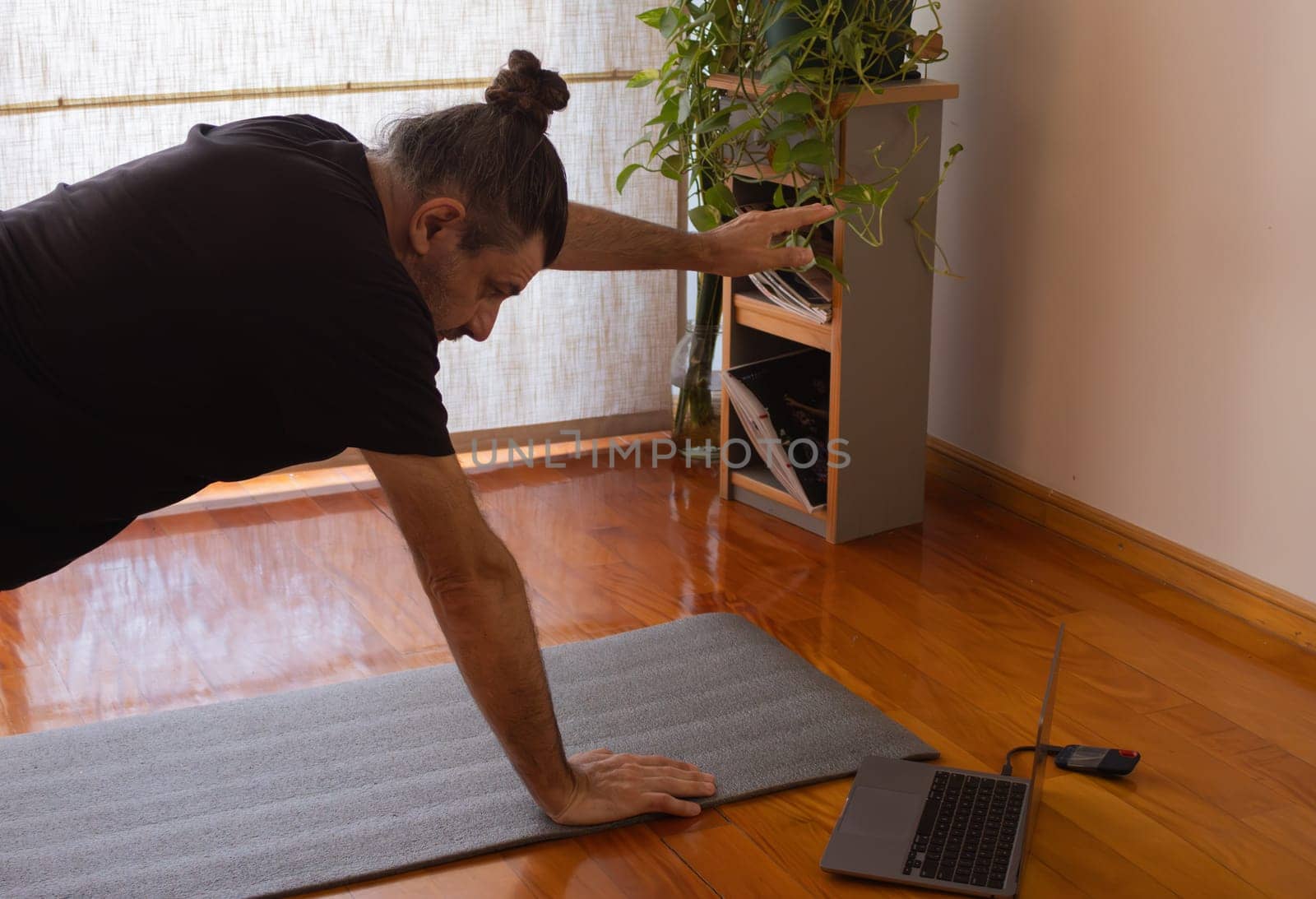 Man in sports suit doing yoga at home.Concept of yoga and meditation. Space for text.Exercise and meditation at home.Sport, fitness and healthy lifestyle concept