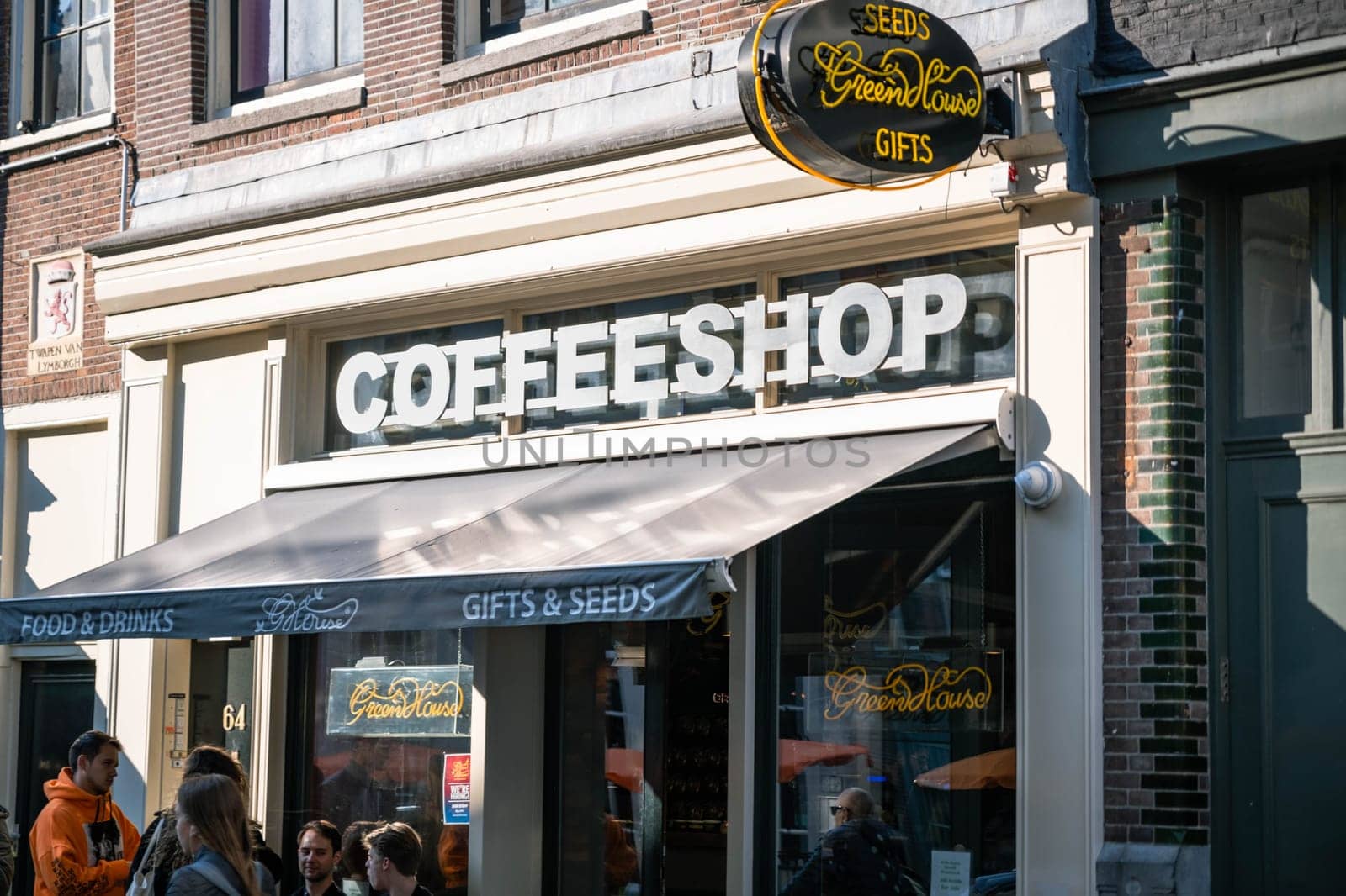 AMSTERDAM, THE NETHERLANDS - APRIL 15, 2019: Coffee shop window with showcase and people
