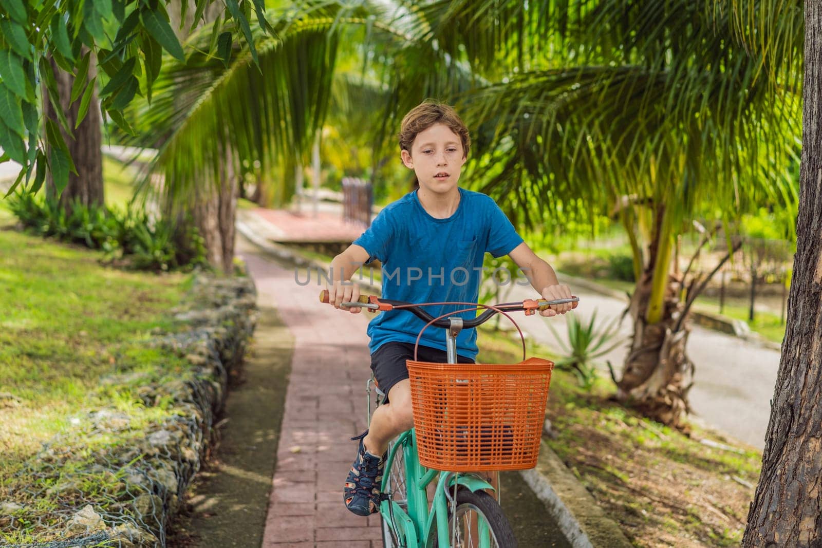 Boy tourist cycling through the charming village of Bacalar, Mexico. Quintana Roo travel, scenic bike paths, and eco-friendly exploration concept.