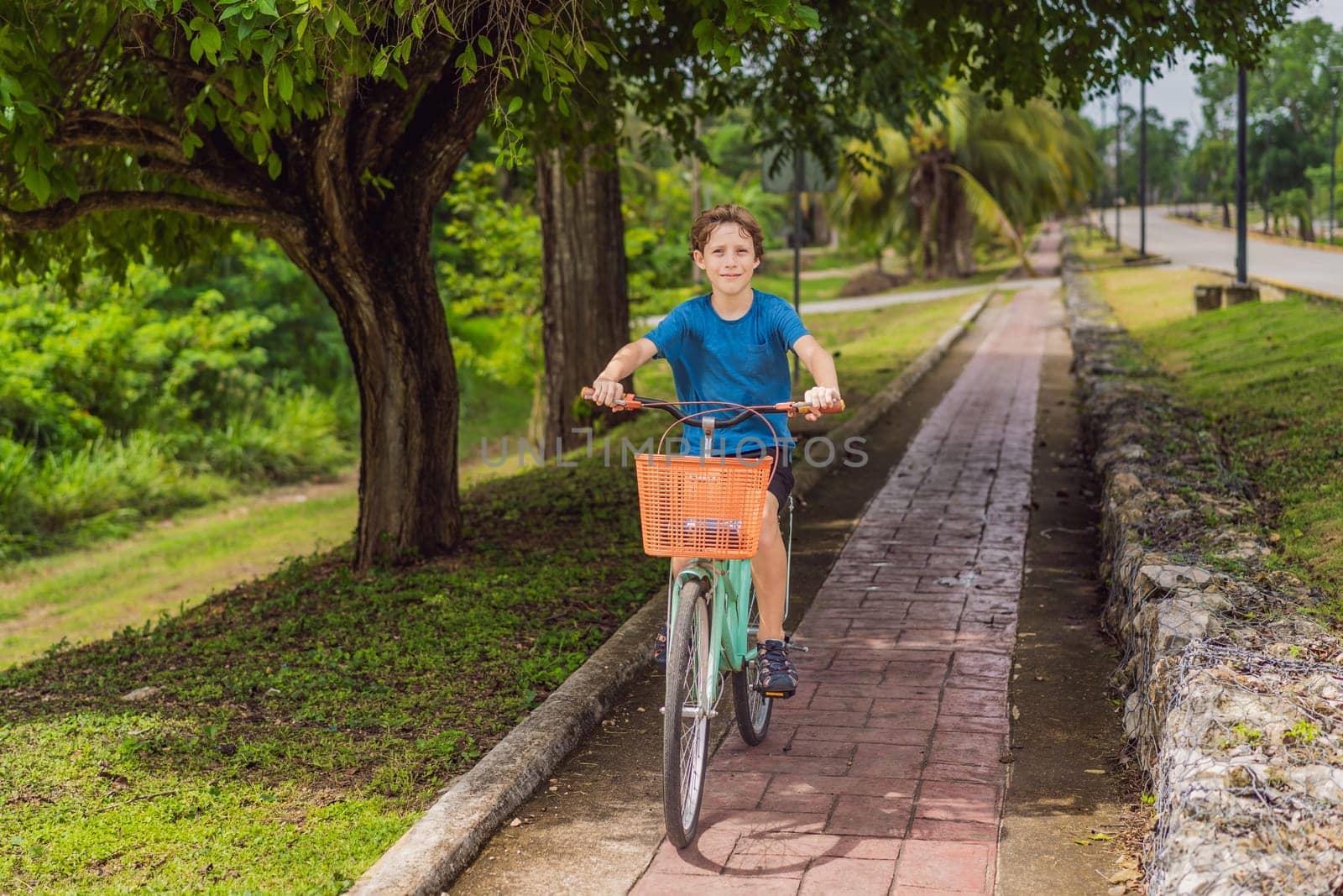 Boy tourist cycling through the charming village of Bacalar, Mexico. Quintana Roo travel, scenic bike paths, and eco-friendly exploration concept.