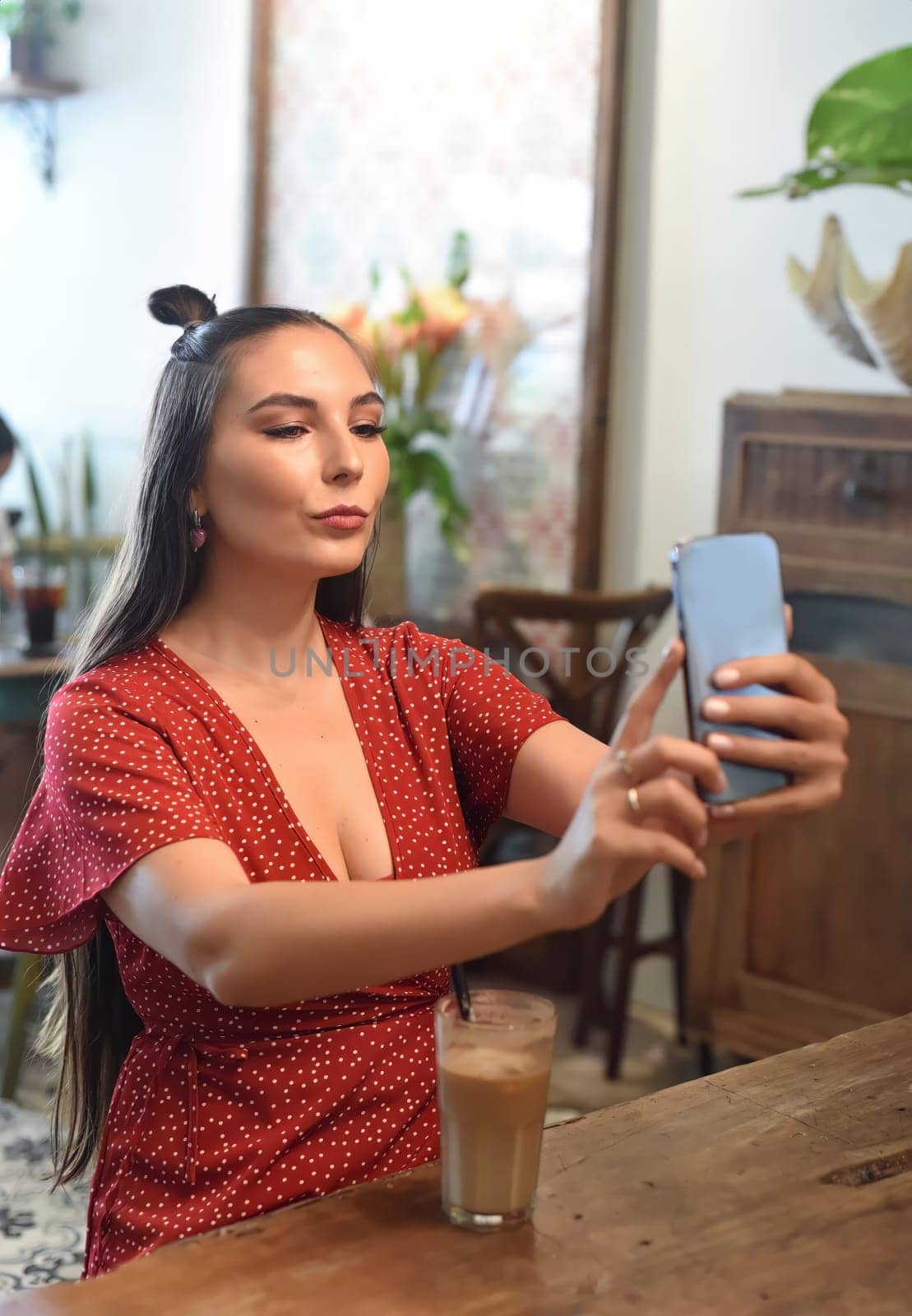 Young woman taking selfie in a coffee shop