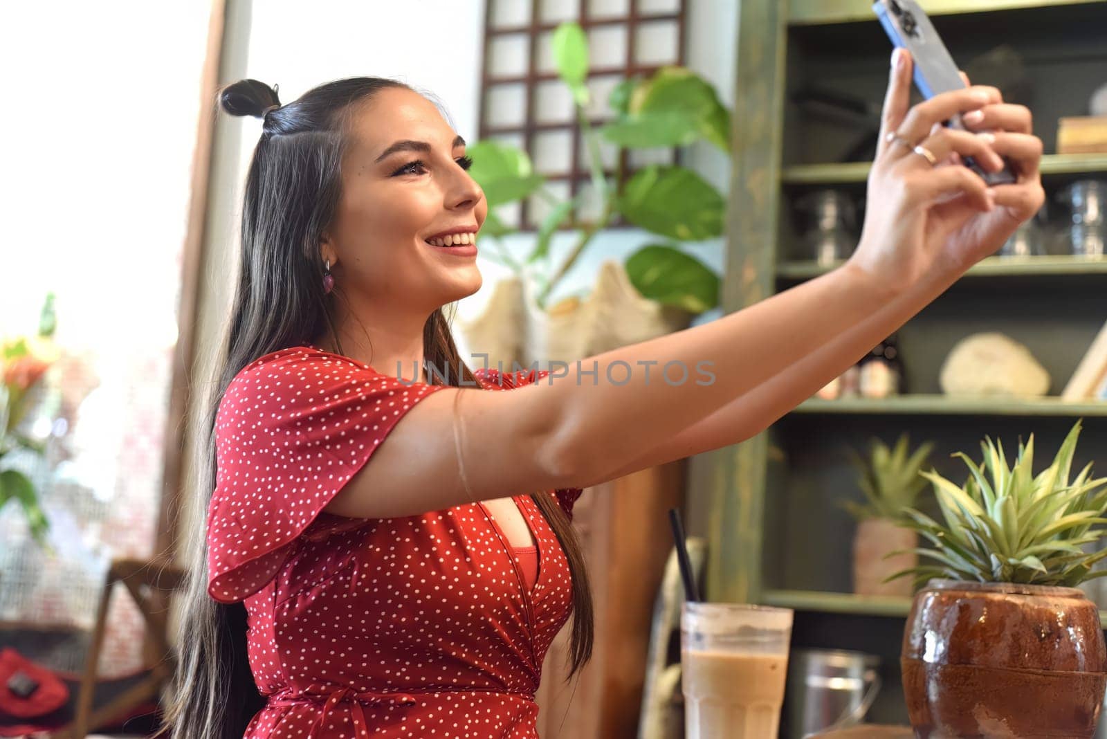 Young woman taking selfie in a coffee shop