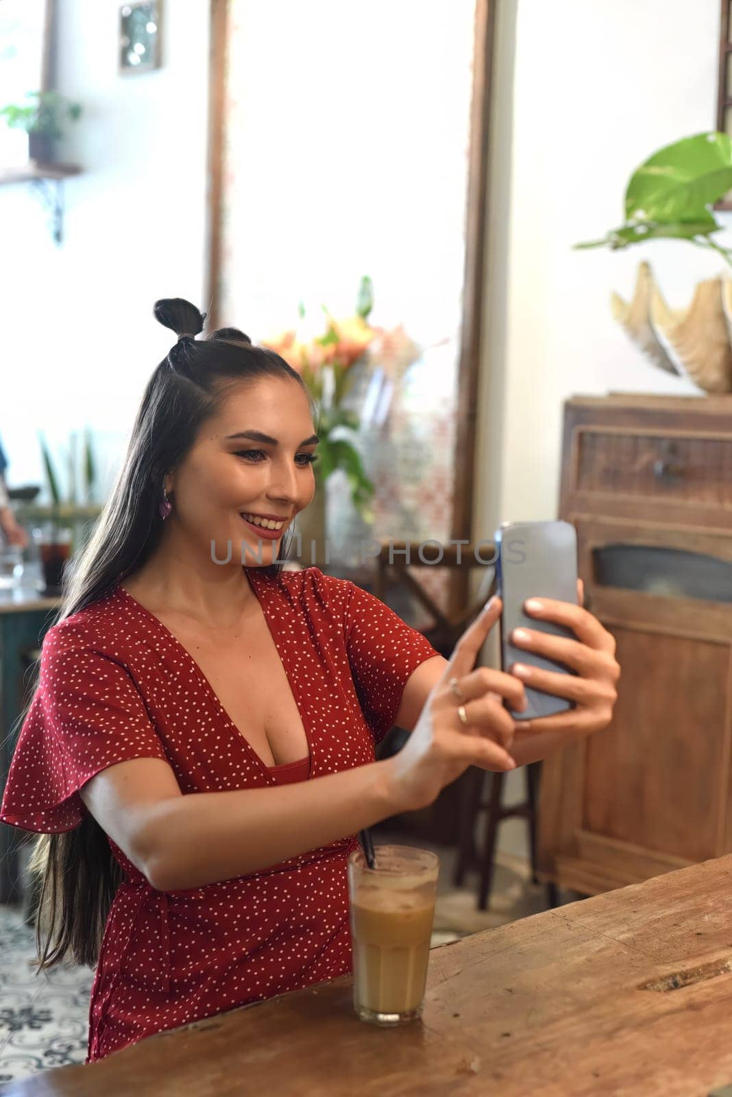 Young woman taking selfie in a coffee shop
