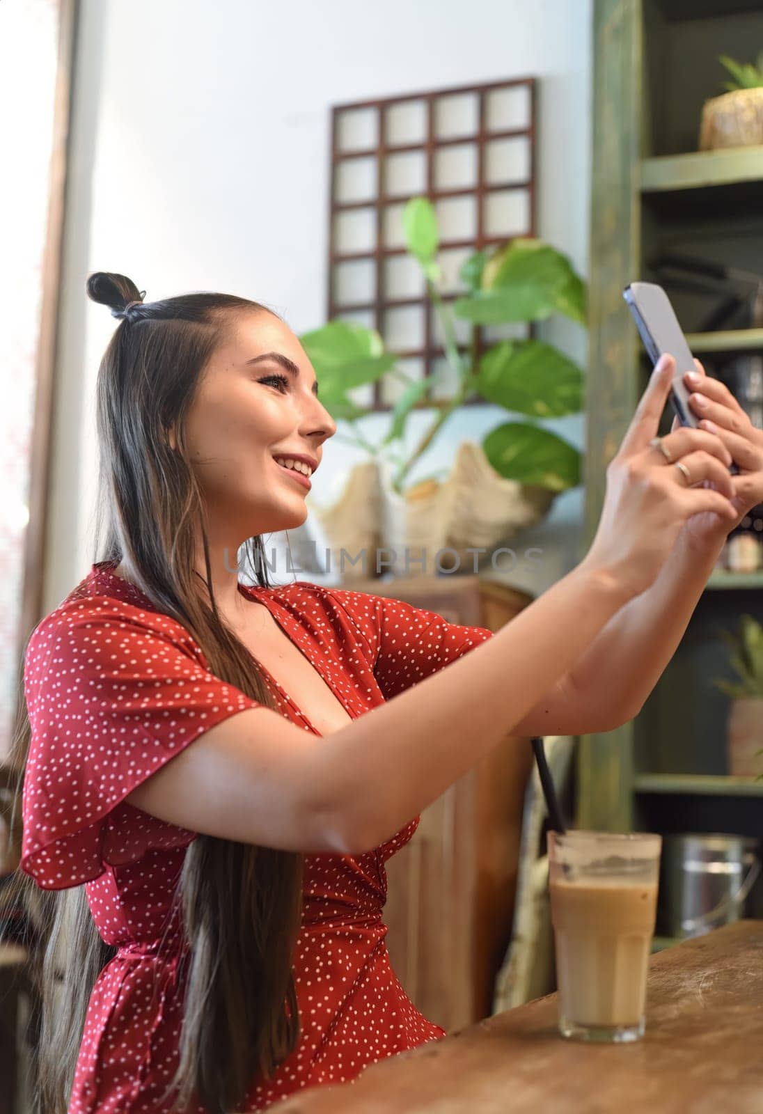 Young woman taking selfie in a coffee shop