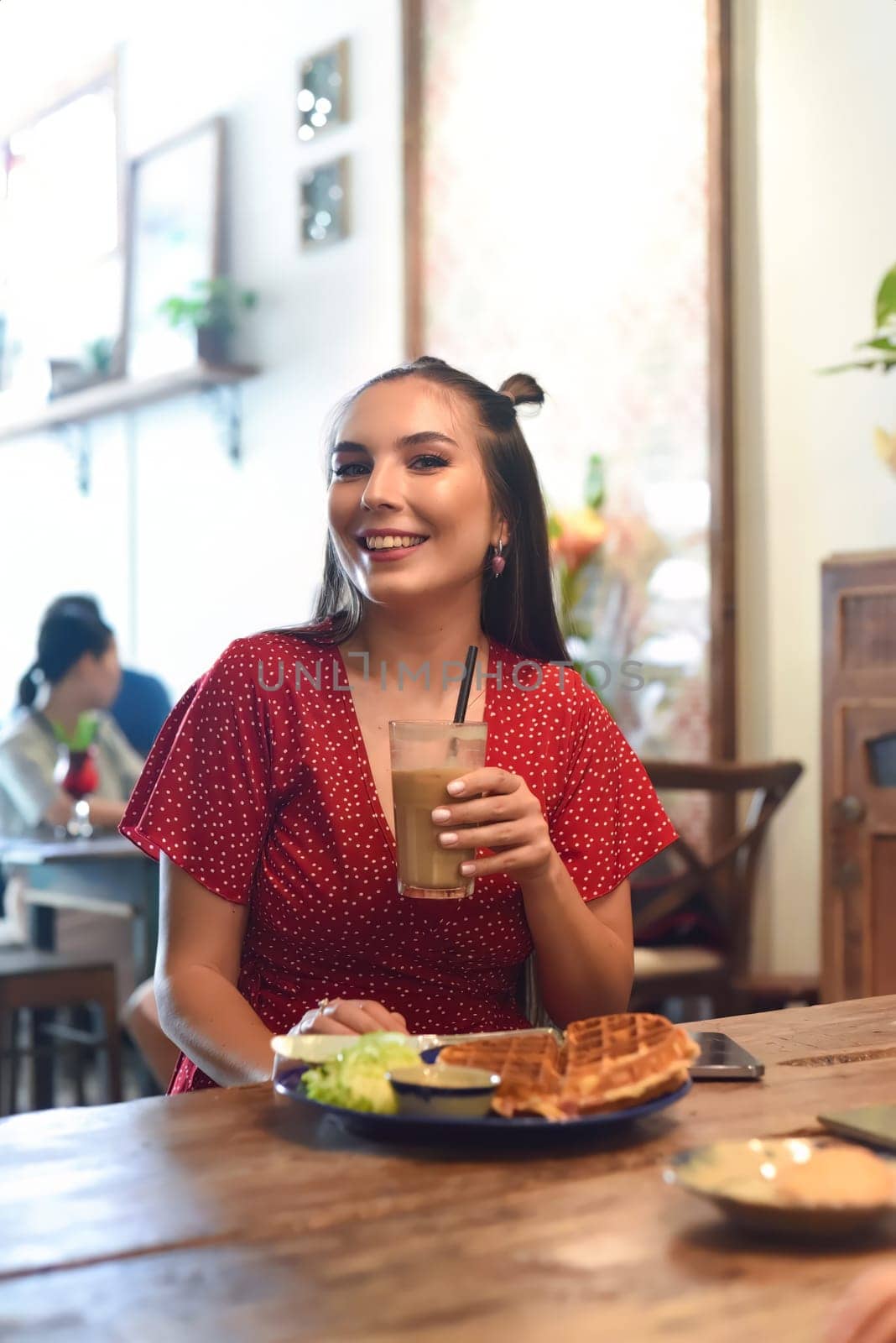 Young woman drinking ice coffee in a coffee shop