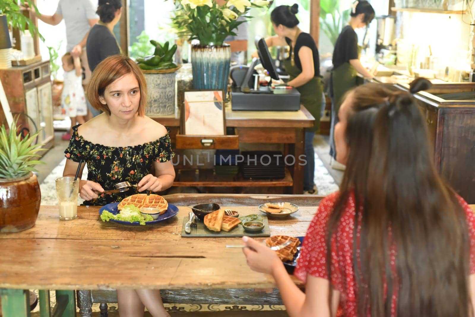 Young women chatting and eating waffles in a cafe