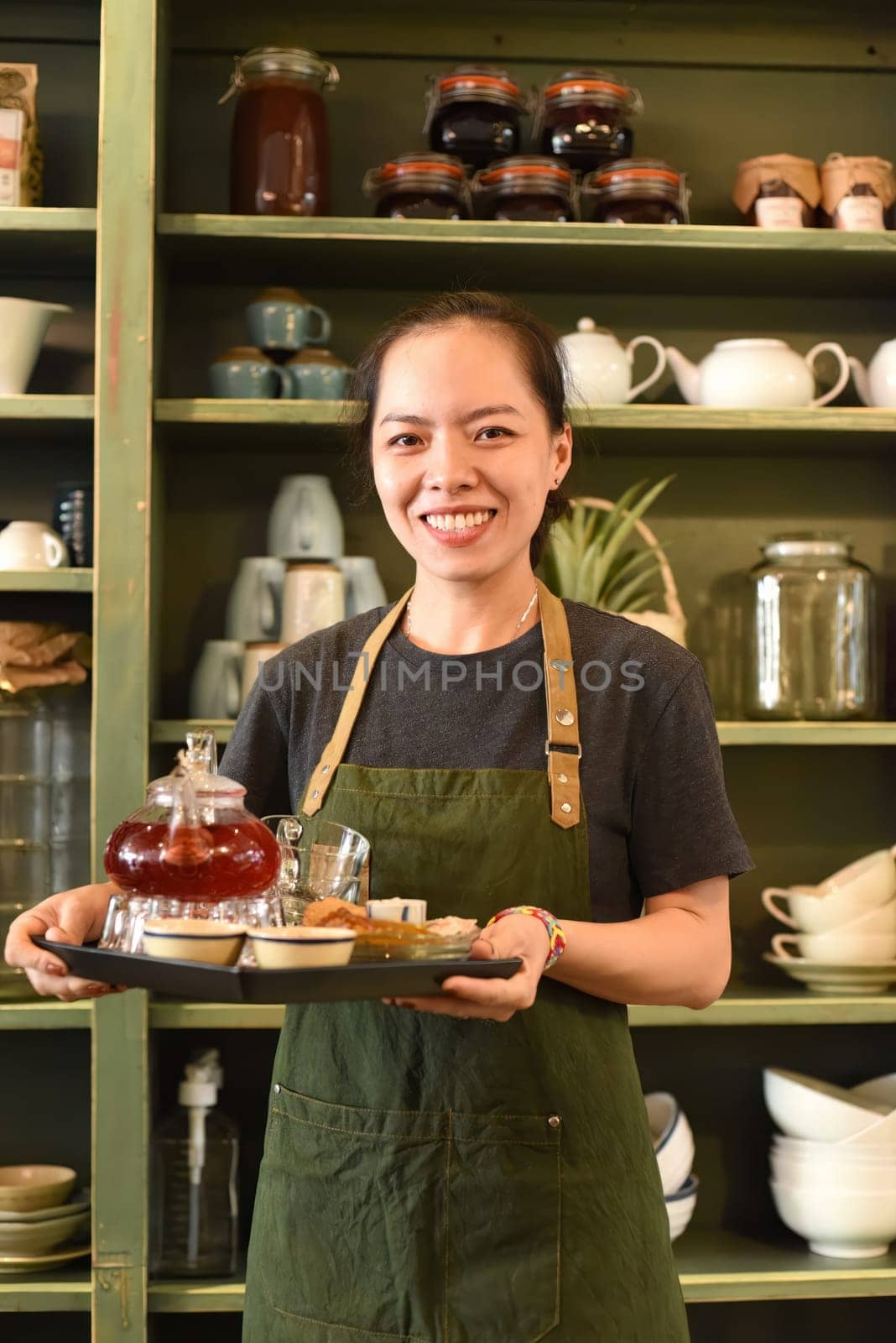 Vietnamese young woman serving tea in a coffee shop