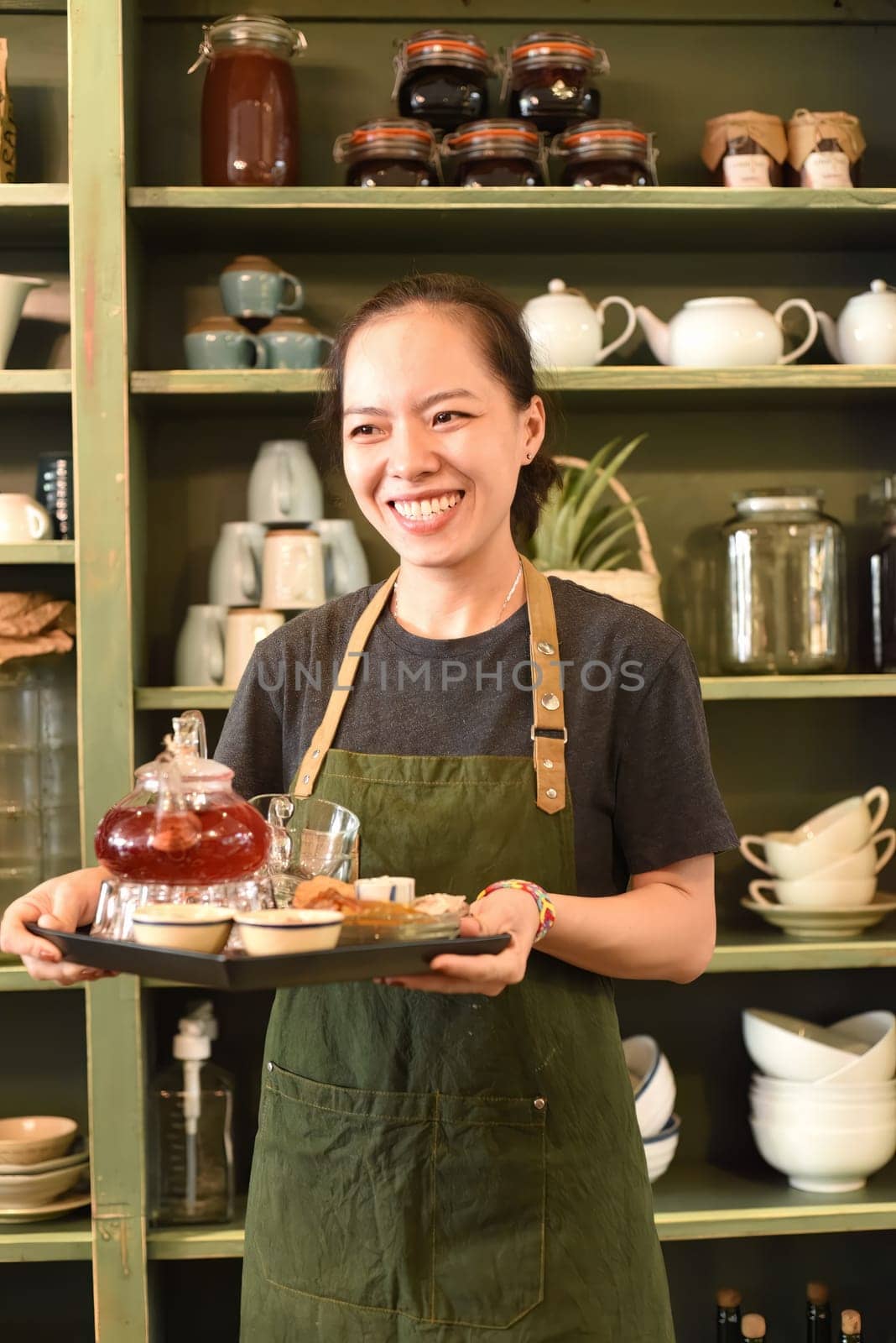 Vietnamese young woman serving tea in a coffee shop