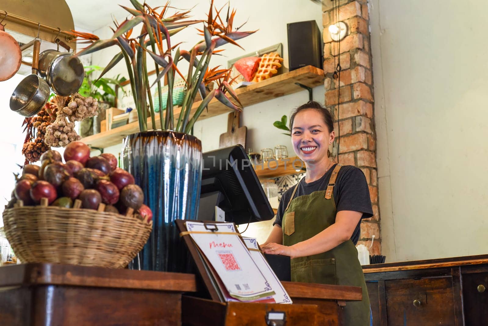Vietnamese happy waitress working in a kitchen of a cafe
