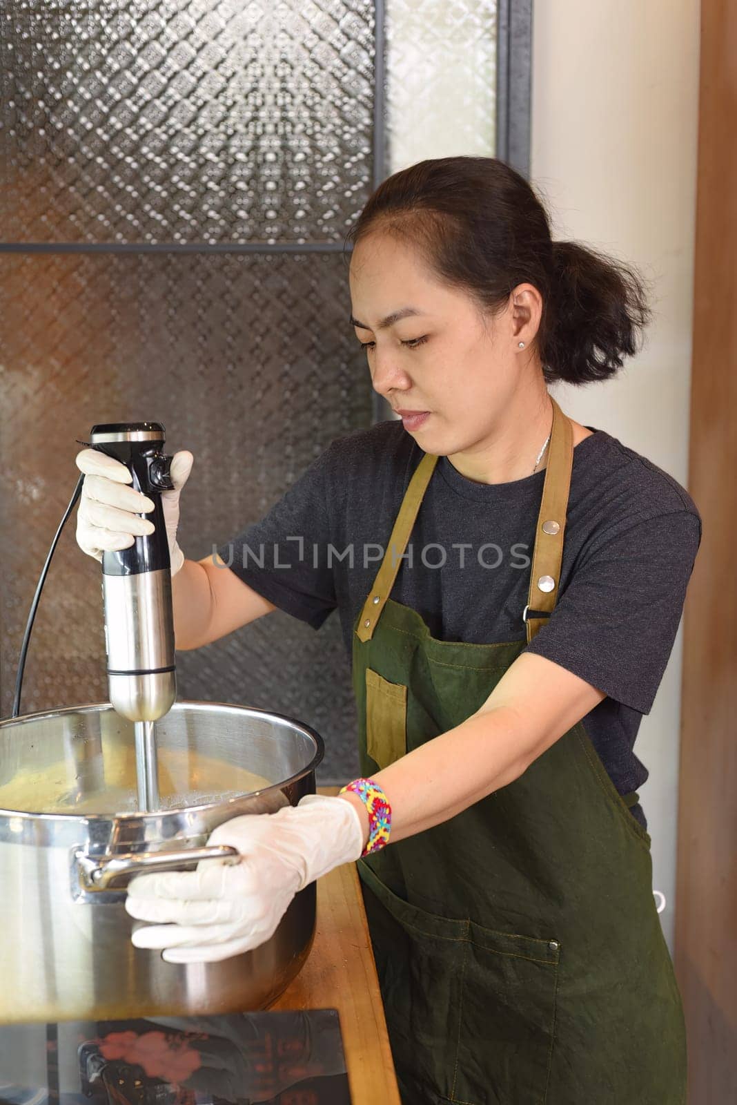 Young vietnamese woman stirs the avocado ice cream base