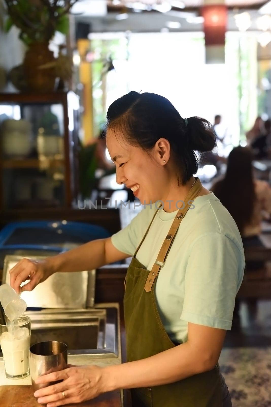 Vietnamese barista using a mixer for condensed milk in glass cup for preparing vietnamese coffee Cafe Sua