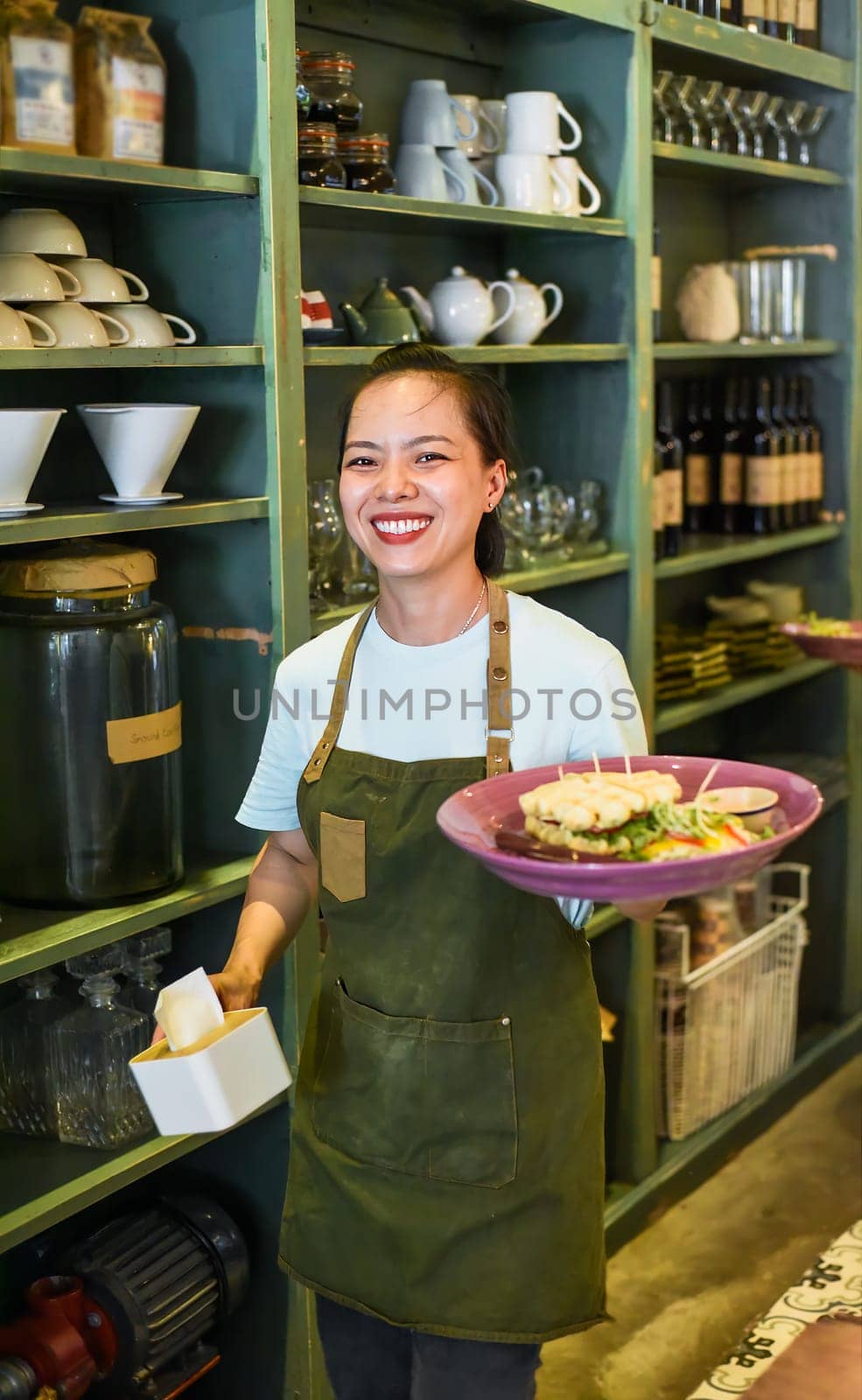 Vietnamese waitress serving belgian waffles with salad in a cafe