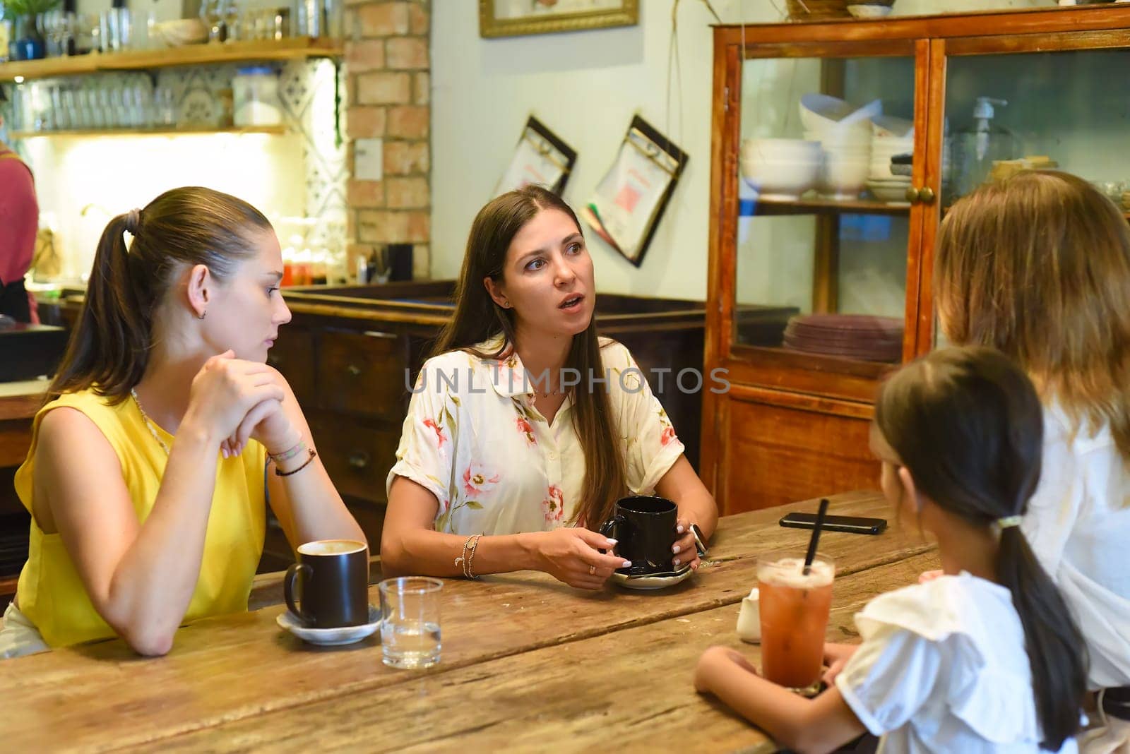 Female best friends talking and eating in a cafe