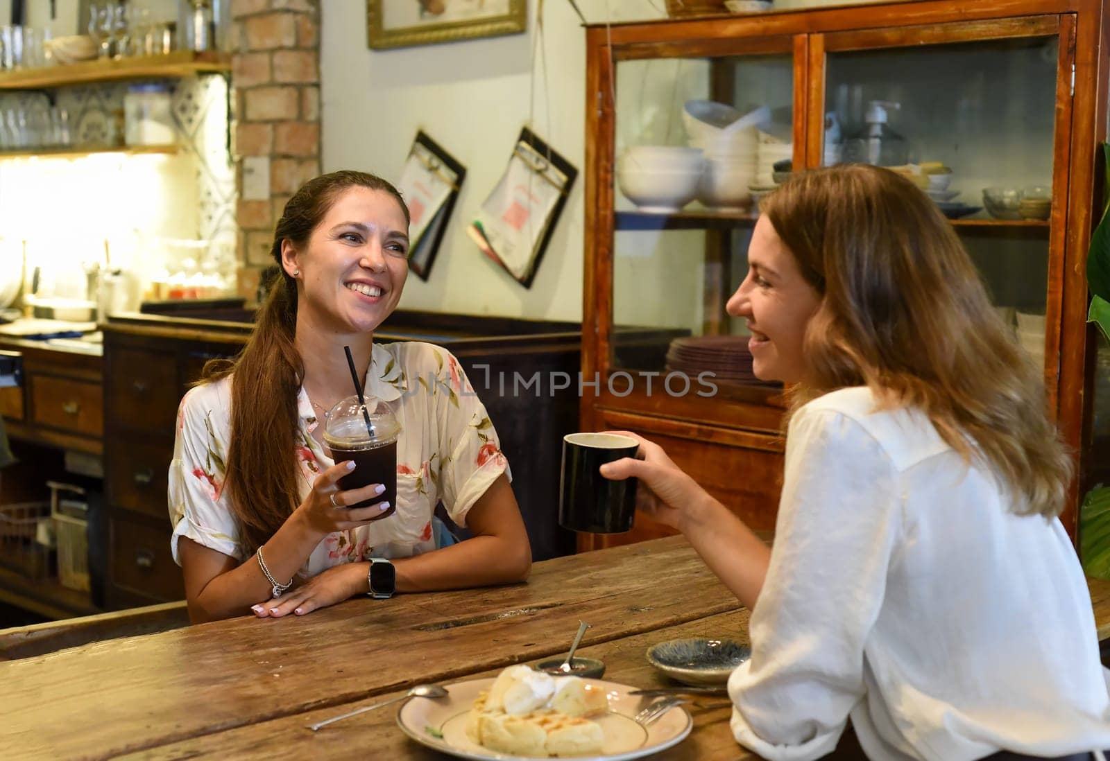 Two best friends talking and drinking coffee in a cafe