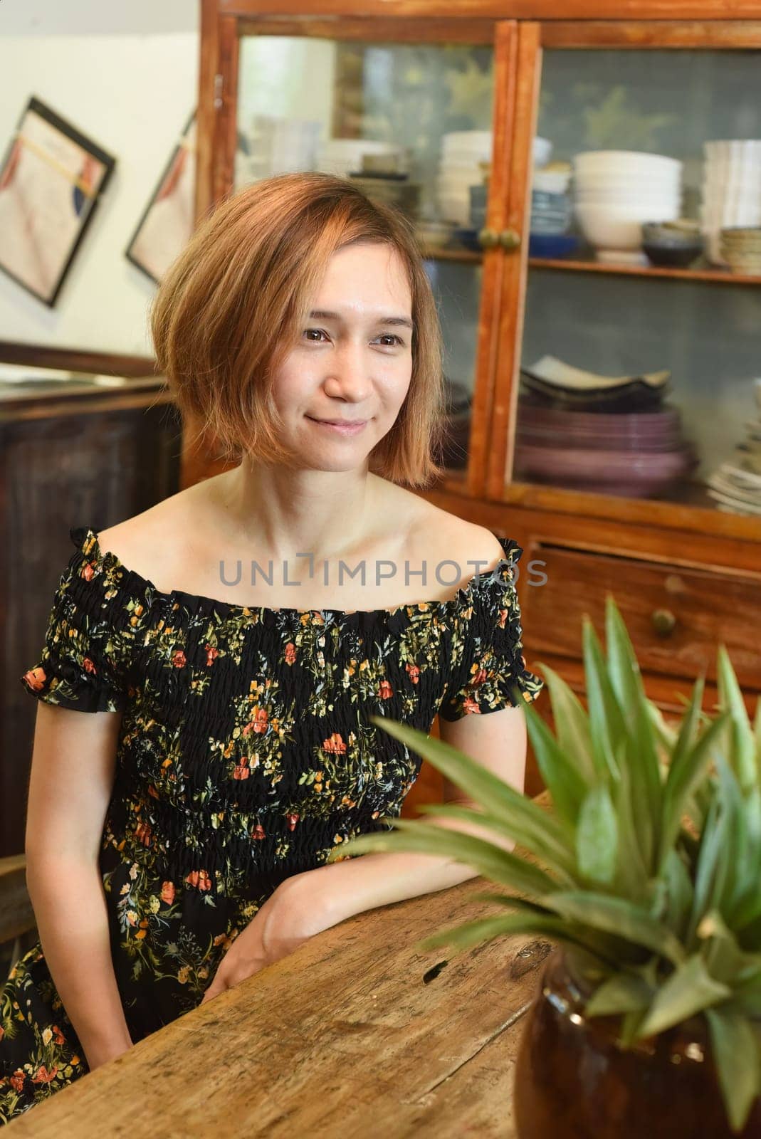 A young woman sitting at wooden table in a coffee house