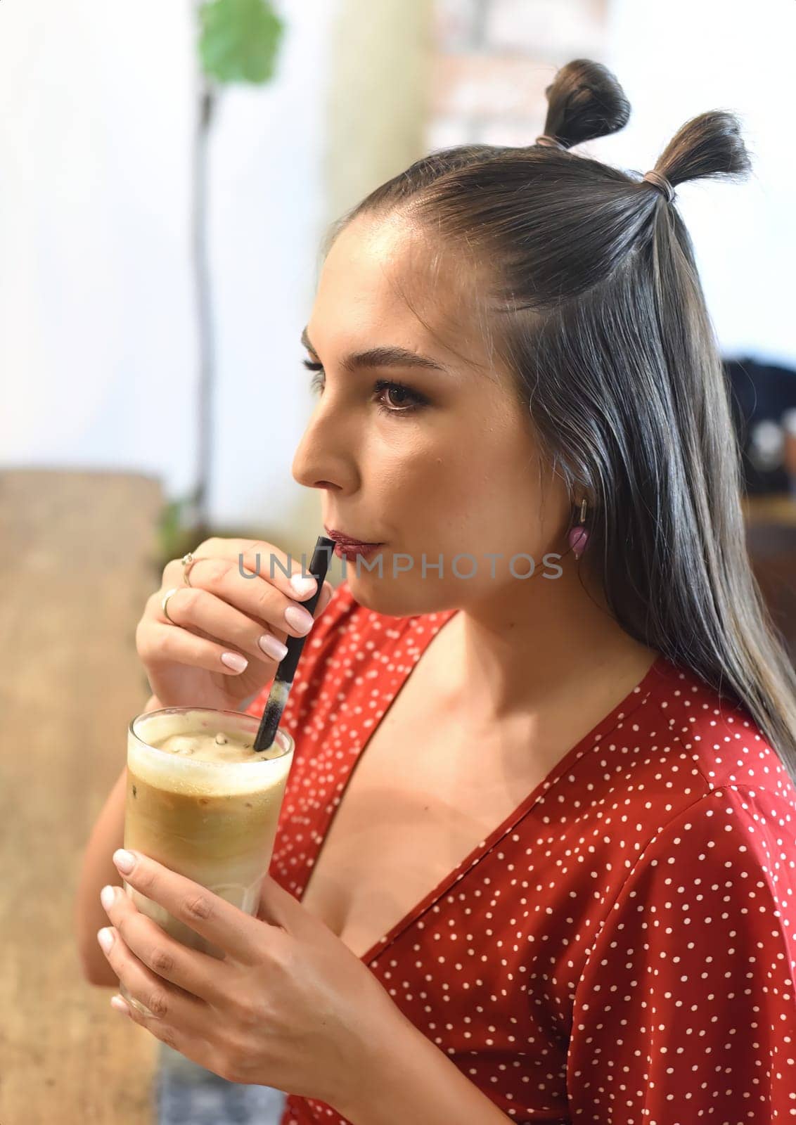 Young woman drinking ice coffee in a coffee shop