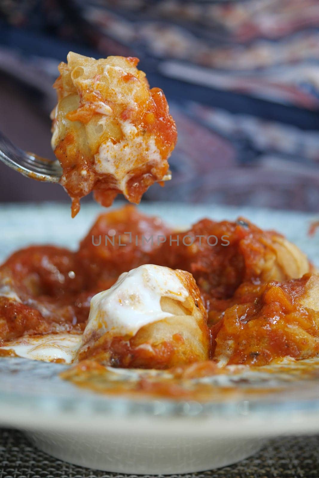 Delicious dumplings topped with hearty tomato sauce and cream are served.