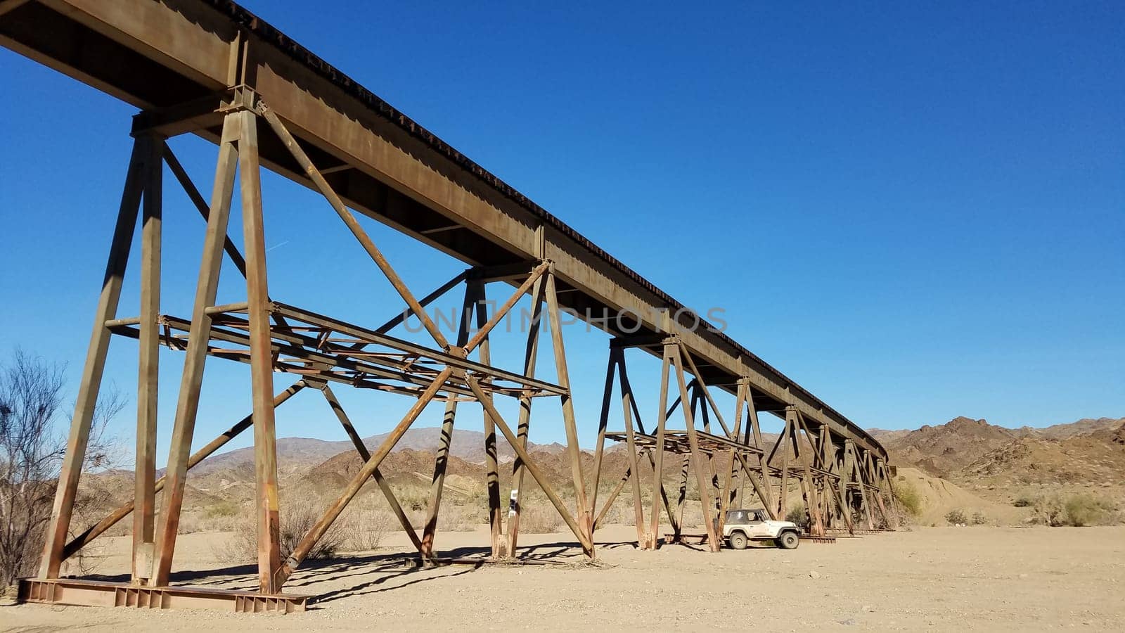 Driving in a Dry Wash Under an Old Train Bridge, Southern California Desert. High quality photo