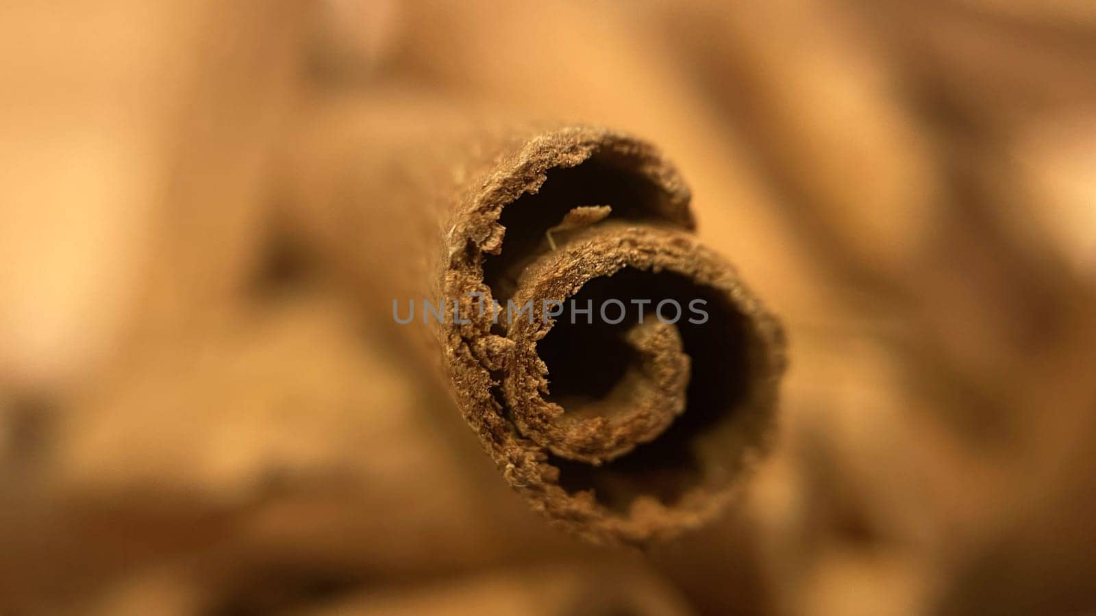 Close-up macro shot of cinnamon sticks showing rich texture and warm brown color.A detailed macro photograph of cinnamon sticks, highlighting their rough texture and curled edges. Perfect for culinary, spice, and aromatic themes.