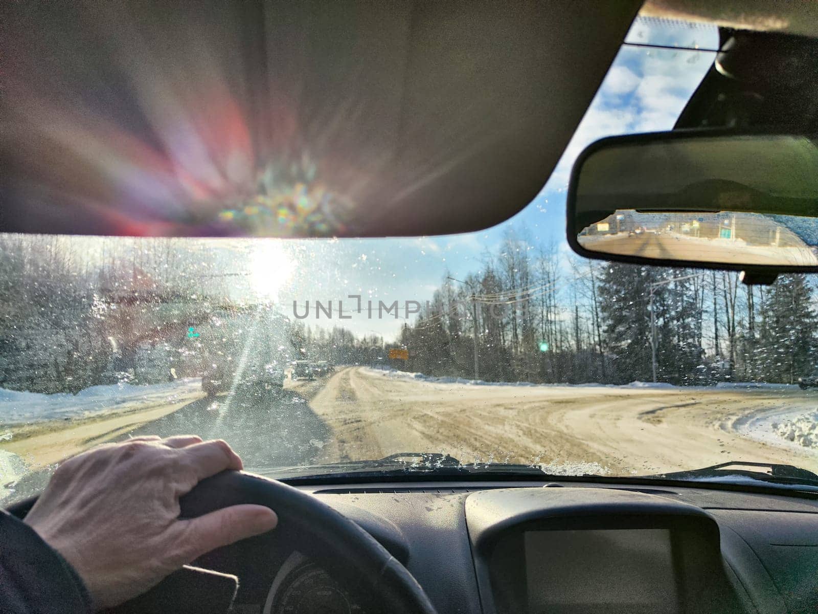 Winter Driving on a winter Snow-Lined Road Under Clear blue Sky. Drivers perspective on a snowy road with one car ahead