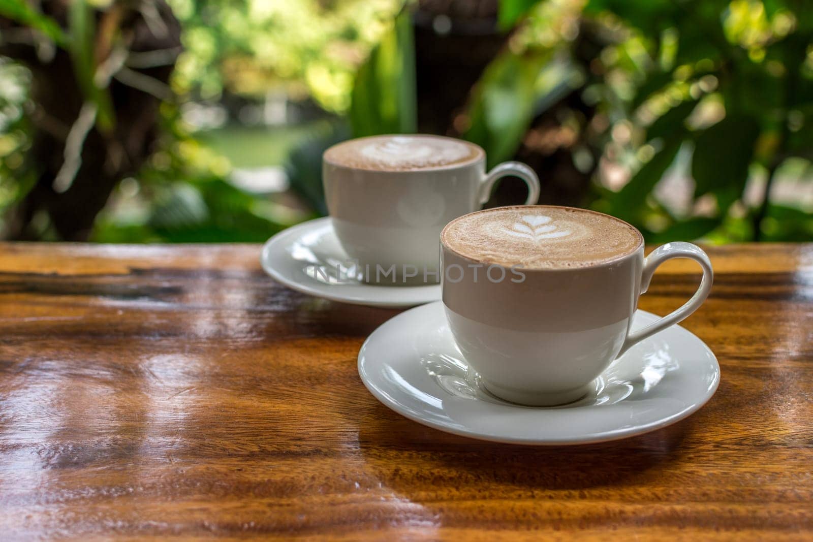 Coffee in white cup on wood table in coffee shop
