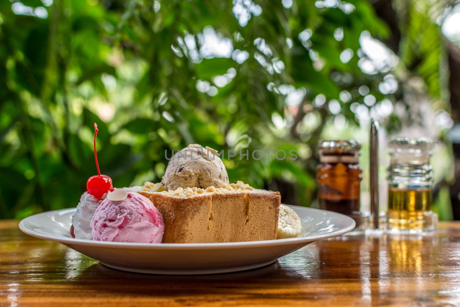 Honey toast with icecream and fruit topped with chocolate syrup and honey is a dessert tasty sweet