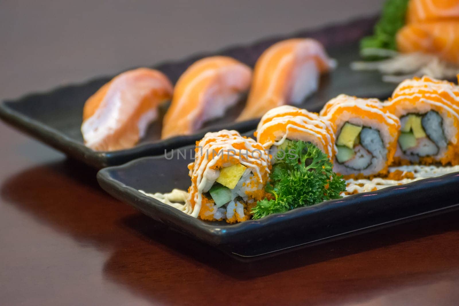 Japanese food in set different types of sushi with seaweed salad and gari (ginger) is a healthy food at the upper right of the serving board in japanese restaurant