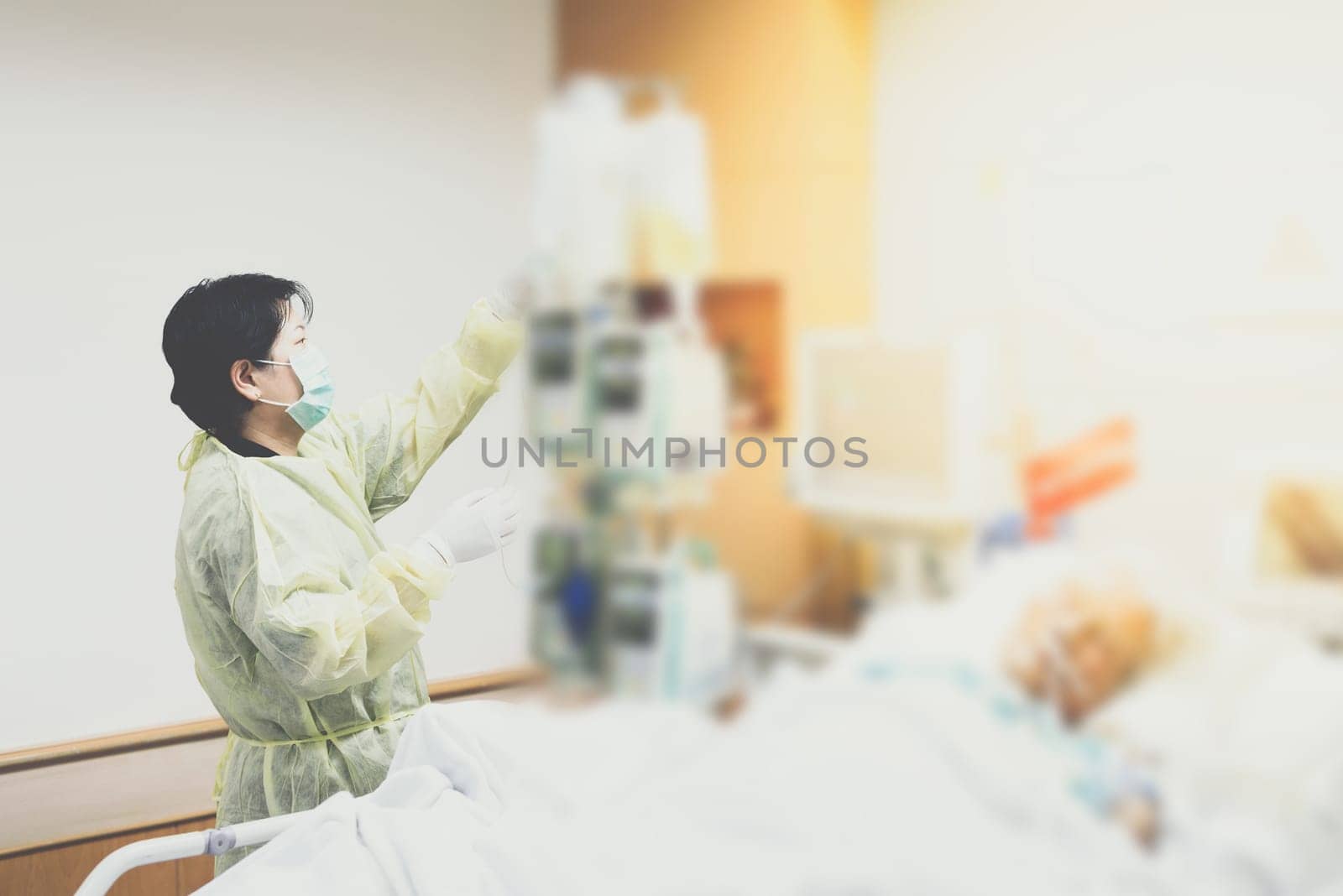 Asian women 40s years old is a patient relative taking care of the CRE. or VRE. infected elder patient 80s years old on patient bed in intensive care unit (ICU.) room at hospital.