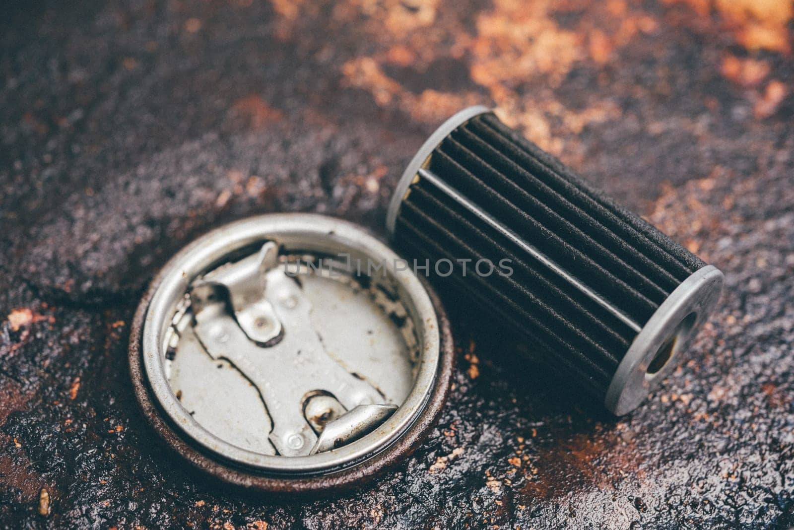 Old lubricant engine oil filter at car garage after changing the new oil filter for repair or maintenance in a car engine