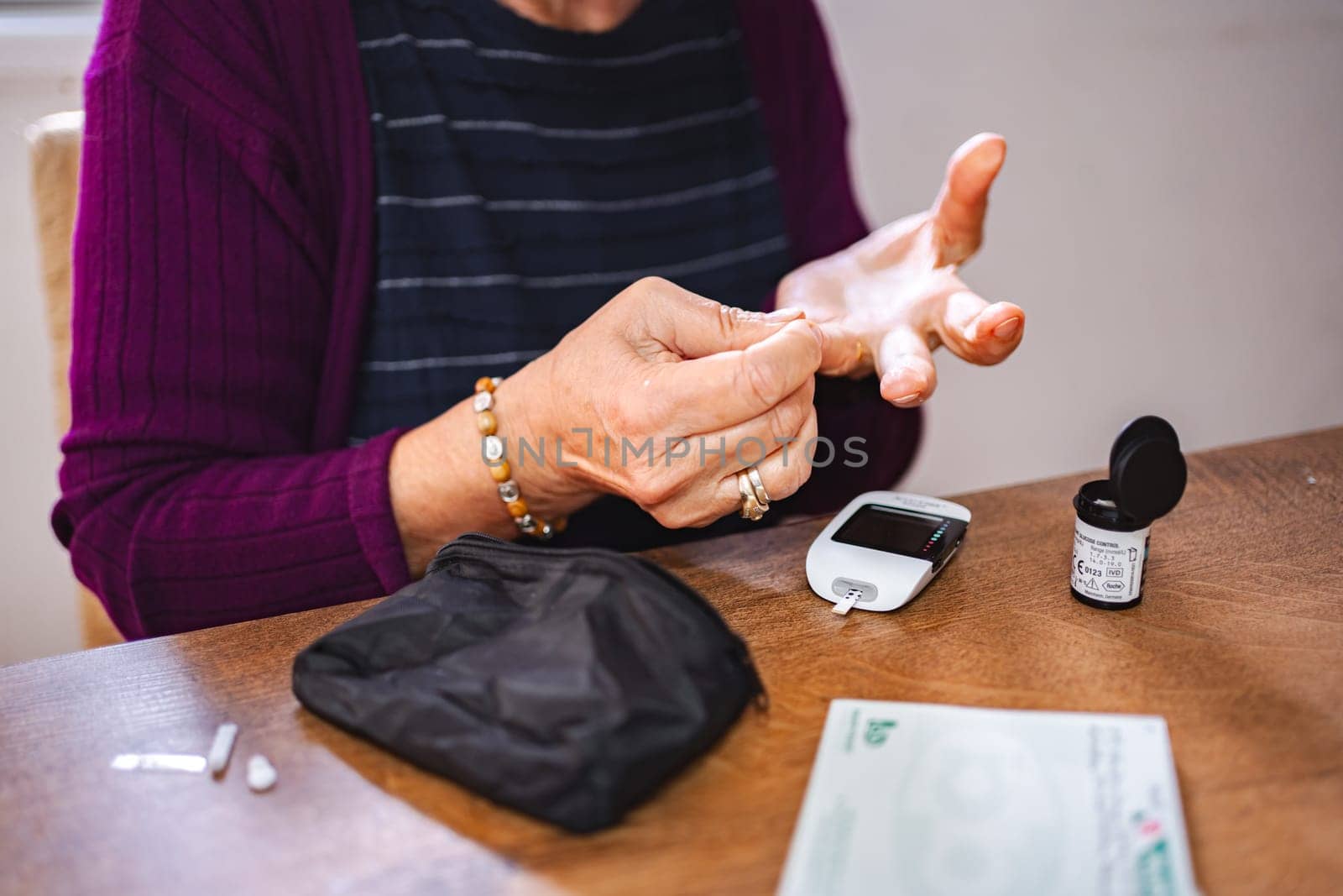 Woman monitors her blood sugar levels using a glucose meter at home.