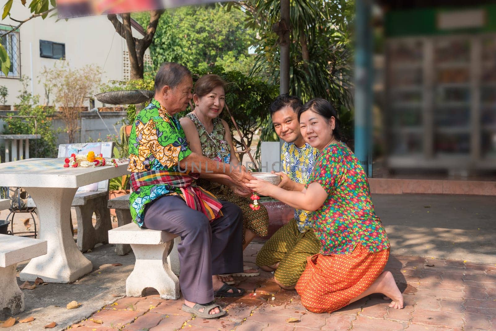 Asian young bathe with respect to parents by water have a jasmine and rose flower and aromatherapy in water in water bowl in Songkran Festival