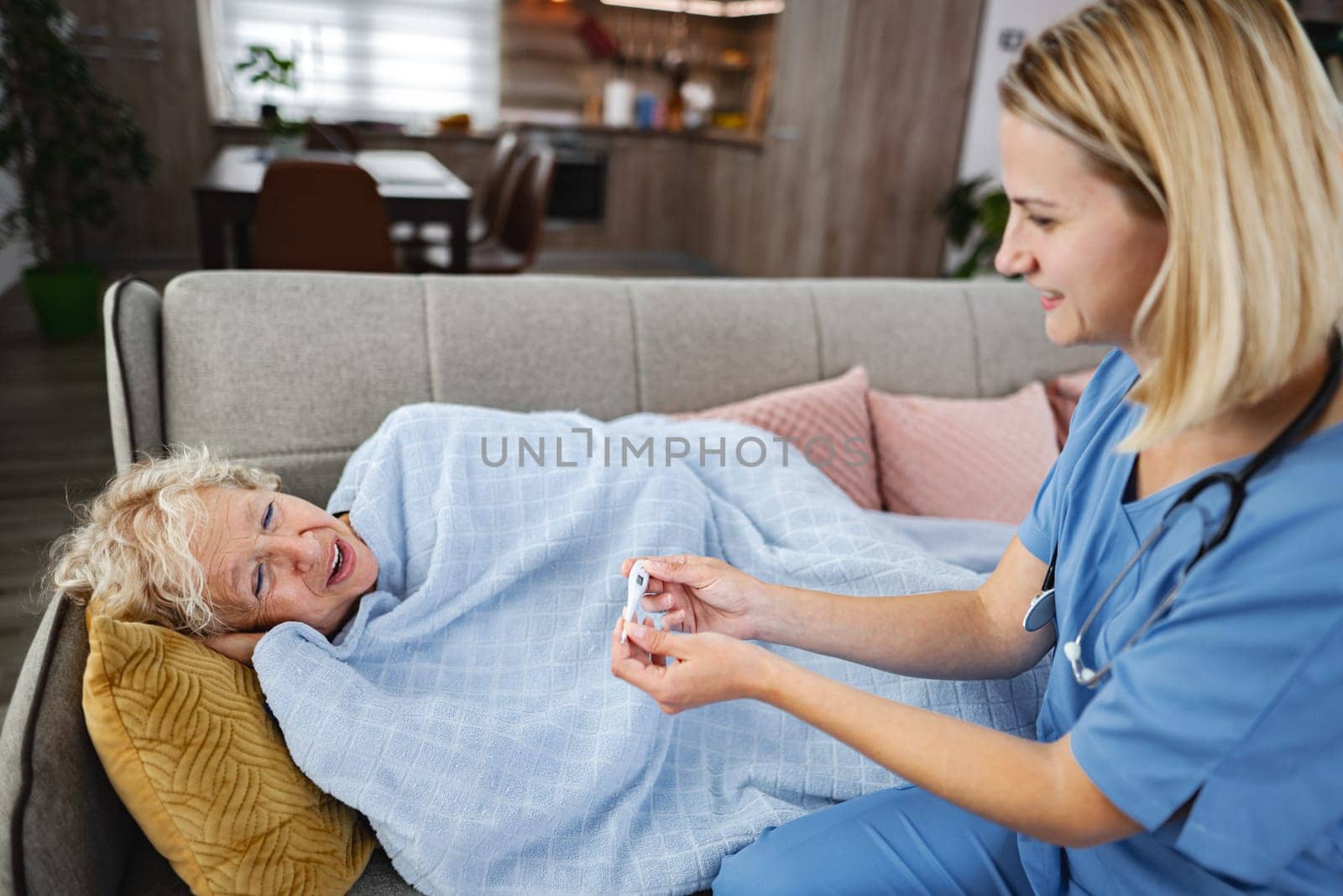 Compassionate caregiver attends to a senior in a warm, inviting home.