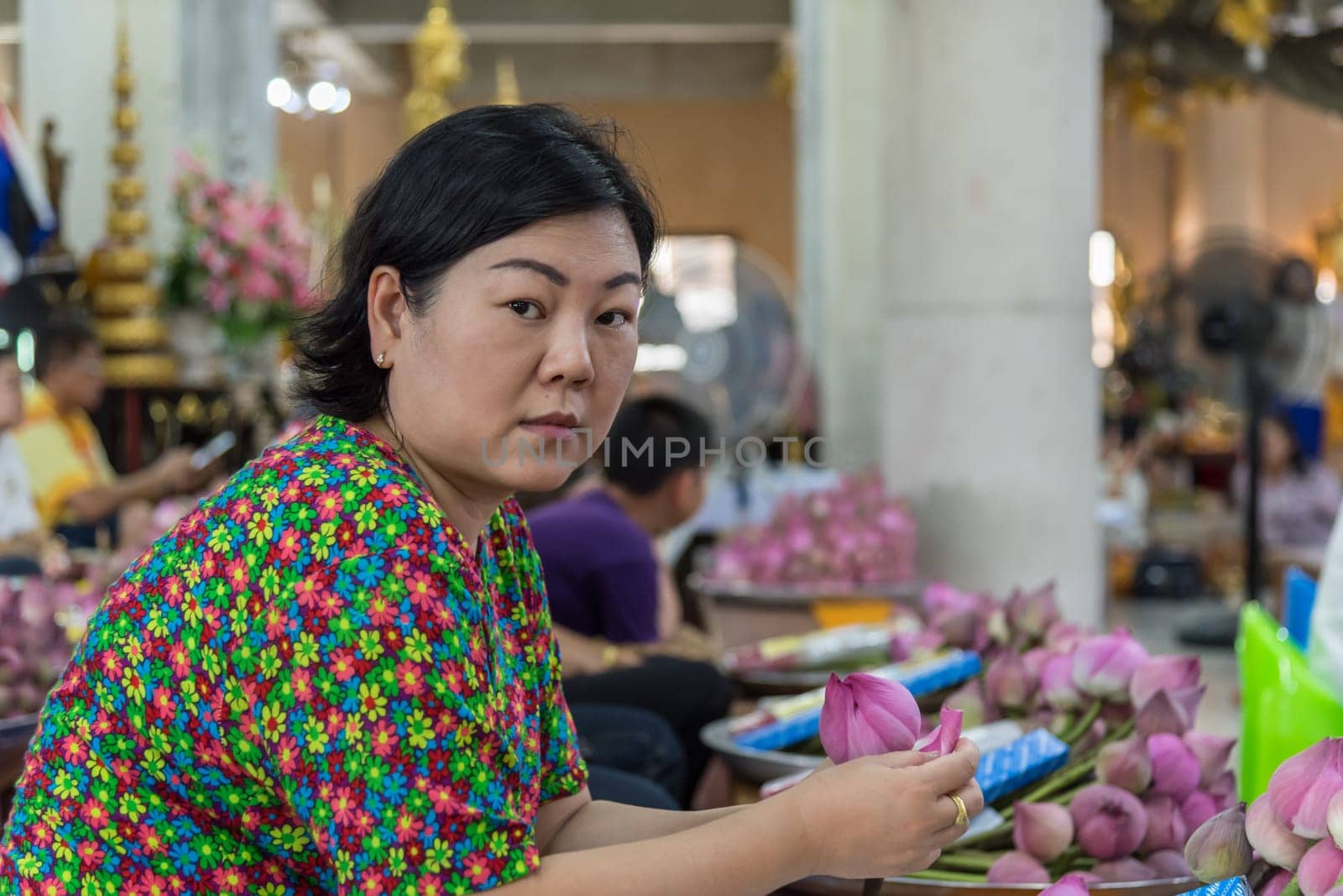 Thai buddhism people in buddhist pray for benefaction worship by incense and garland to Buddha or spirit-house at shrine or Thai temple (Wat Thai)