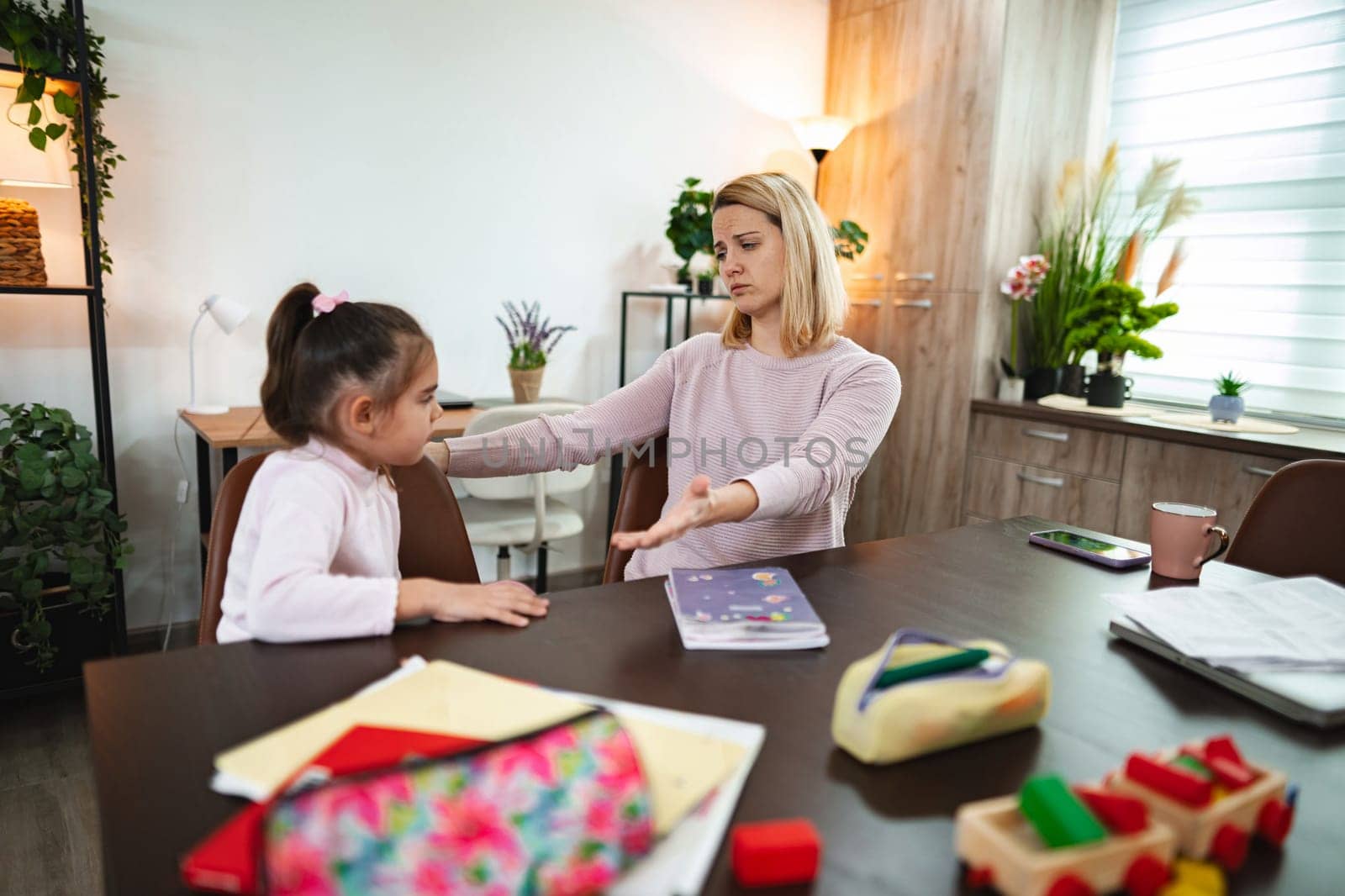A mother and daughter engage in a deep conversation at their cozy dining table.