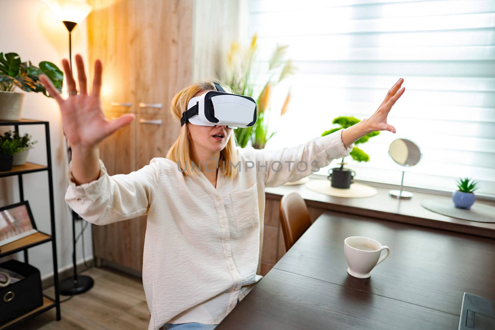 Woman engages with virtual reality, expressing excitement in her cozy room.