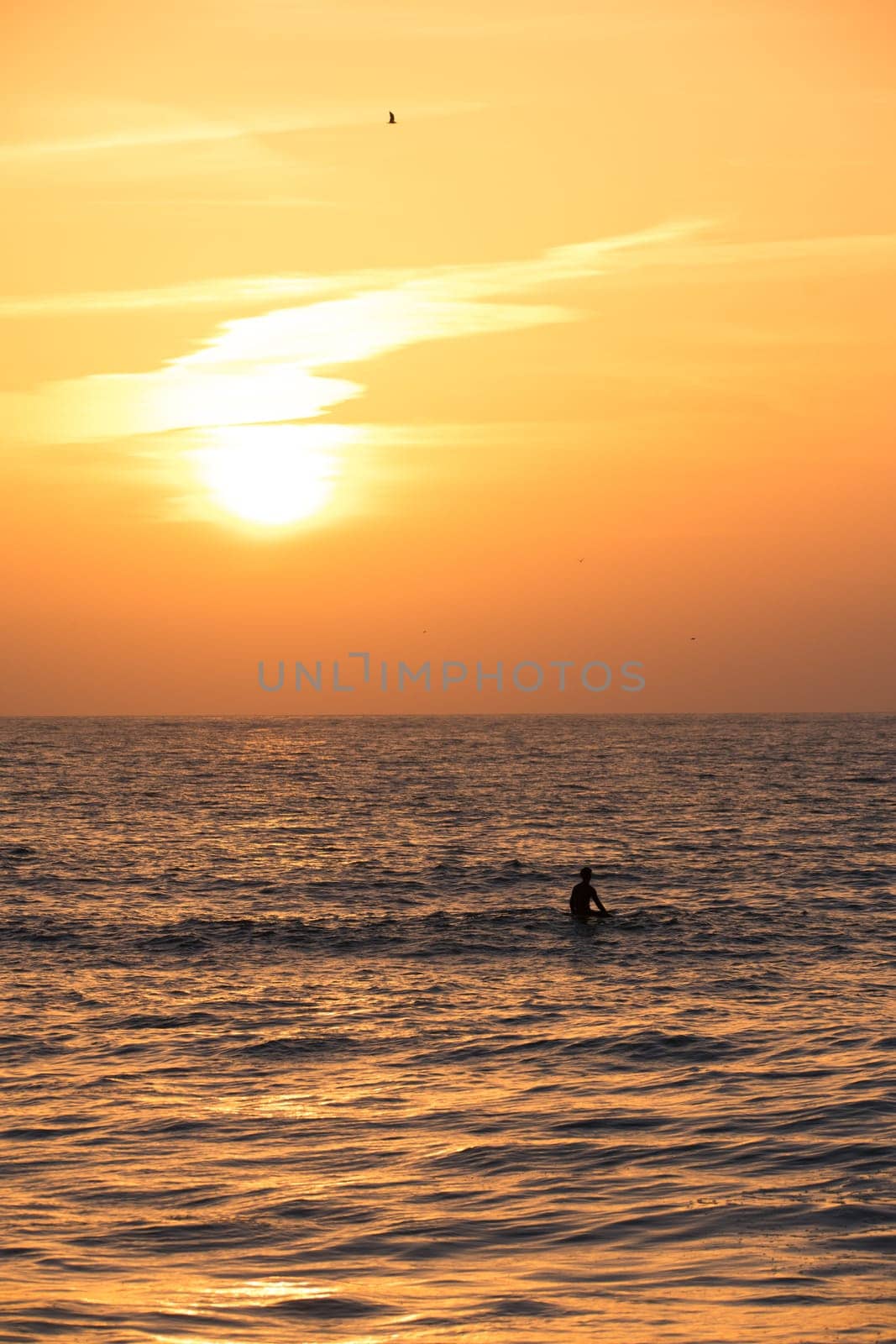 Surfer silhouette in the ocean at sunset by homydesign