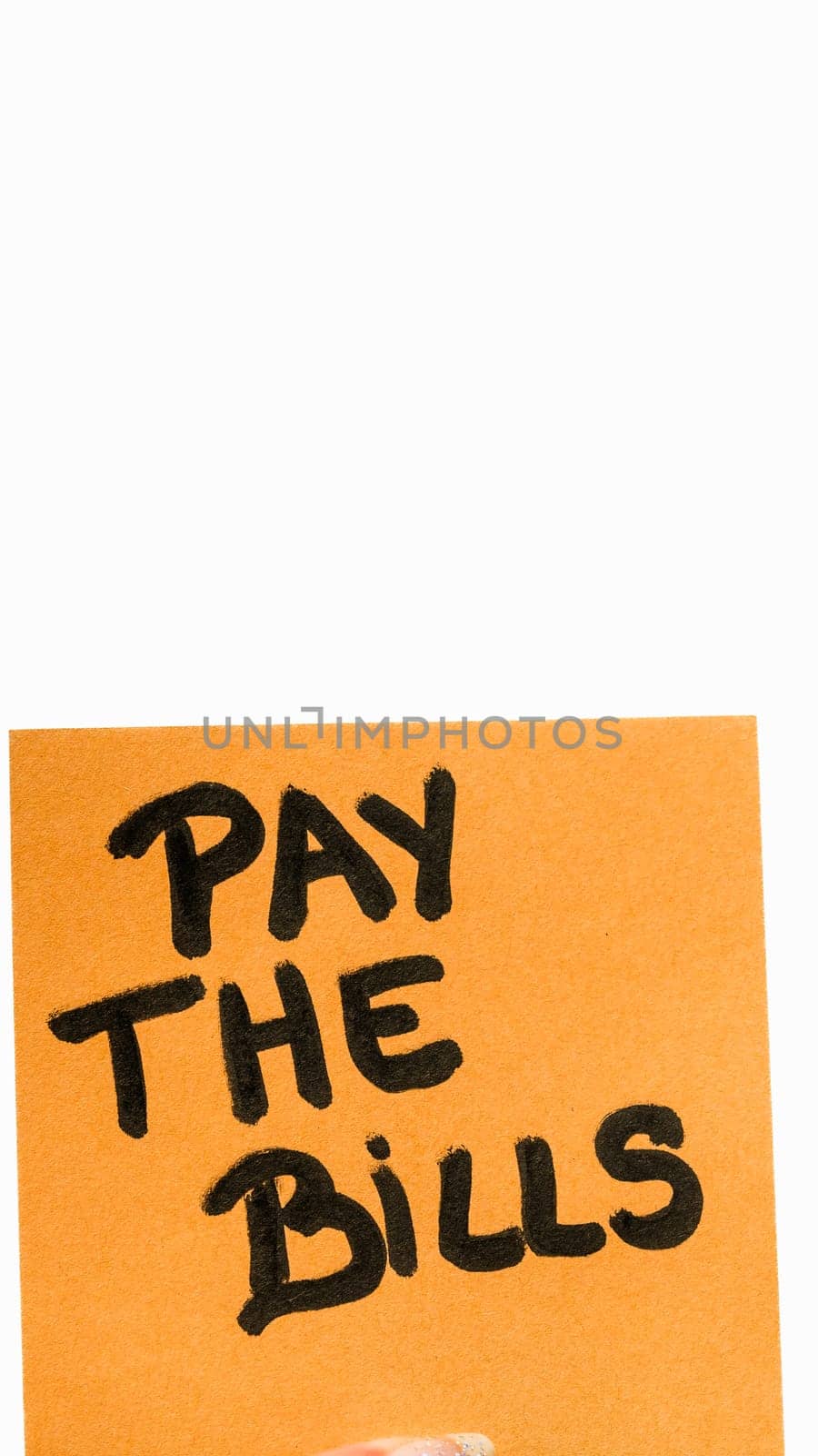 Pay bills handwriting text close up isolated on orange paper with copy space. by vladispas