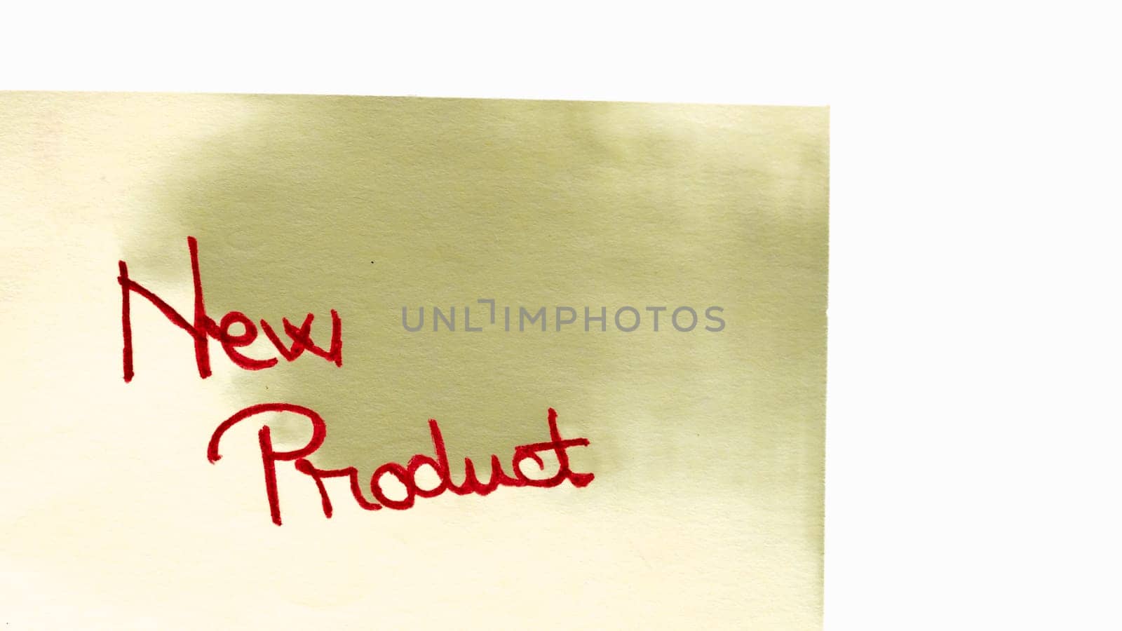 New product handwriting text close up isolated on yellow paper with copy space. by vladispas