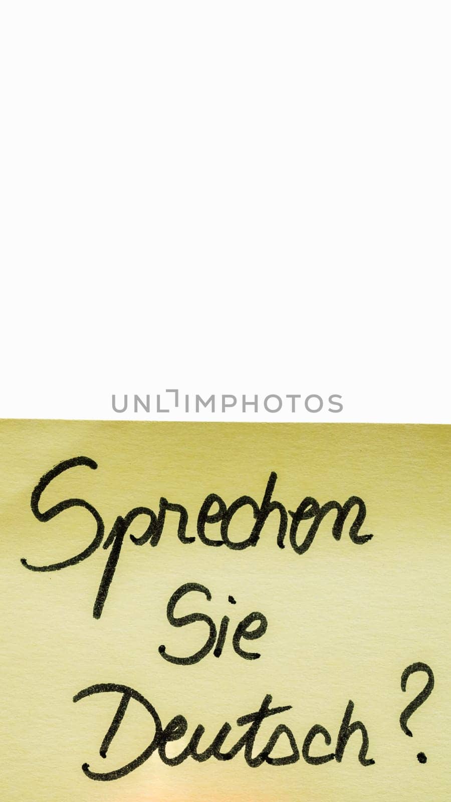 Sprechen sie deutsch ( do you speak german) handwriting text close up isolated on yellow paper with copy space. by vladispas
