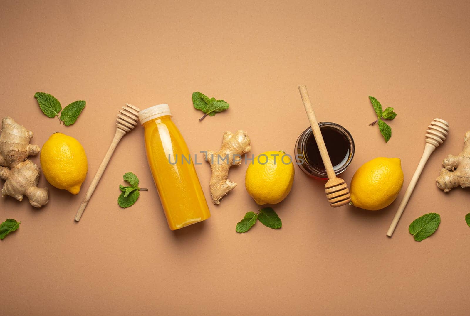 Composition with detox drink, lemons, mint, ginger, honey in glass jar and honey wooden dippers top view. Food for immunity stimulation and against flu. Healthy natural remedies to boost immune system by its_al_dente