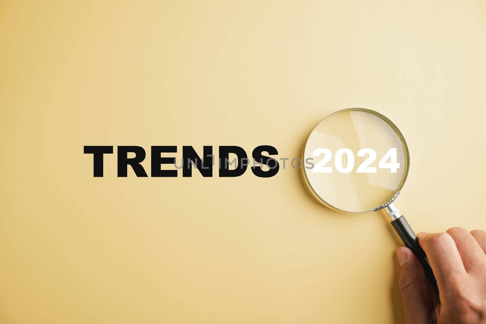 Magnifier glasses display the text New Year 2024 Trends, emphasizing the main trend of change. The image represents popular and relevant topics, new trends in business, and evaluation methods.