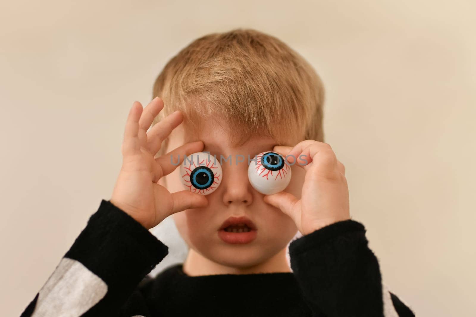A boy fooling around with capillary eyes on Halloween