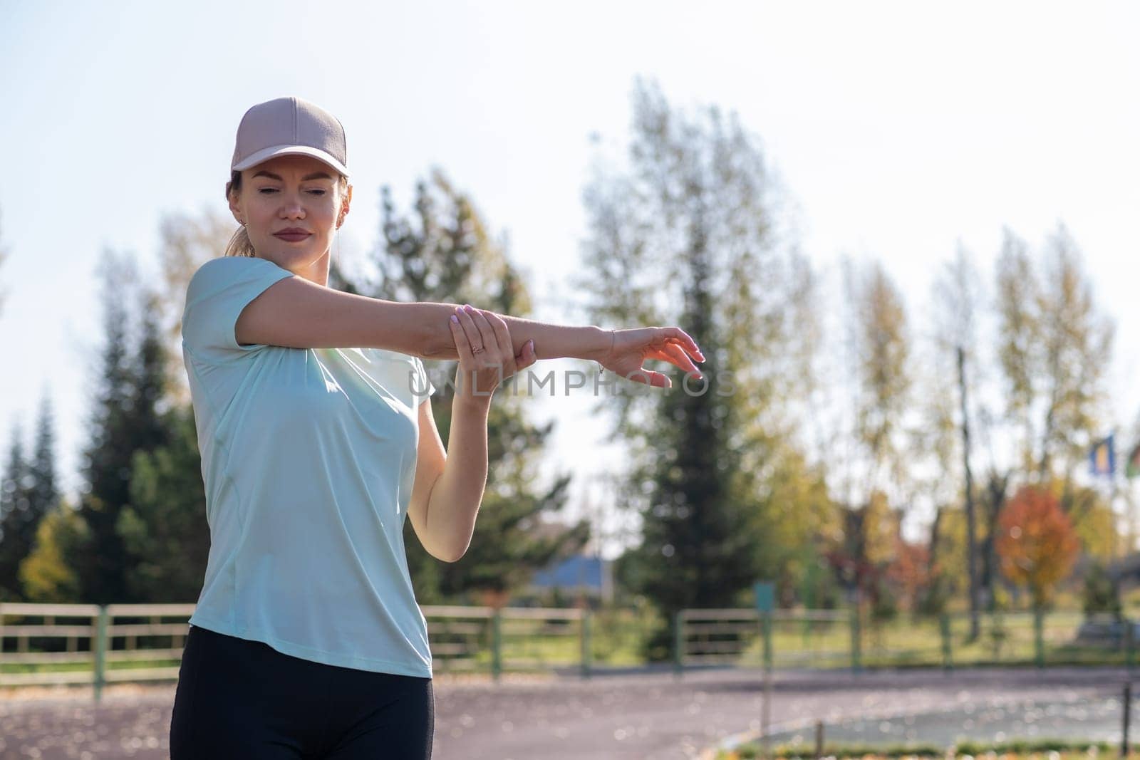 A young beautiful woman in sportswear plays sports at a local stadium by AnatoliiFoto