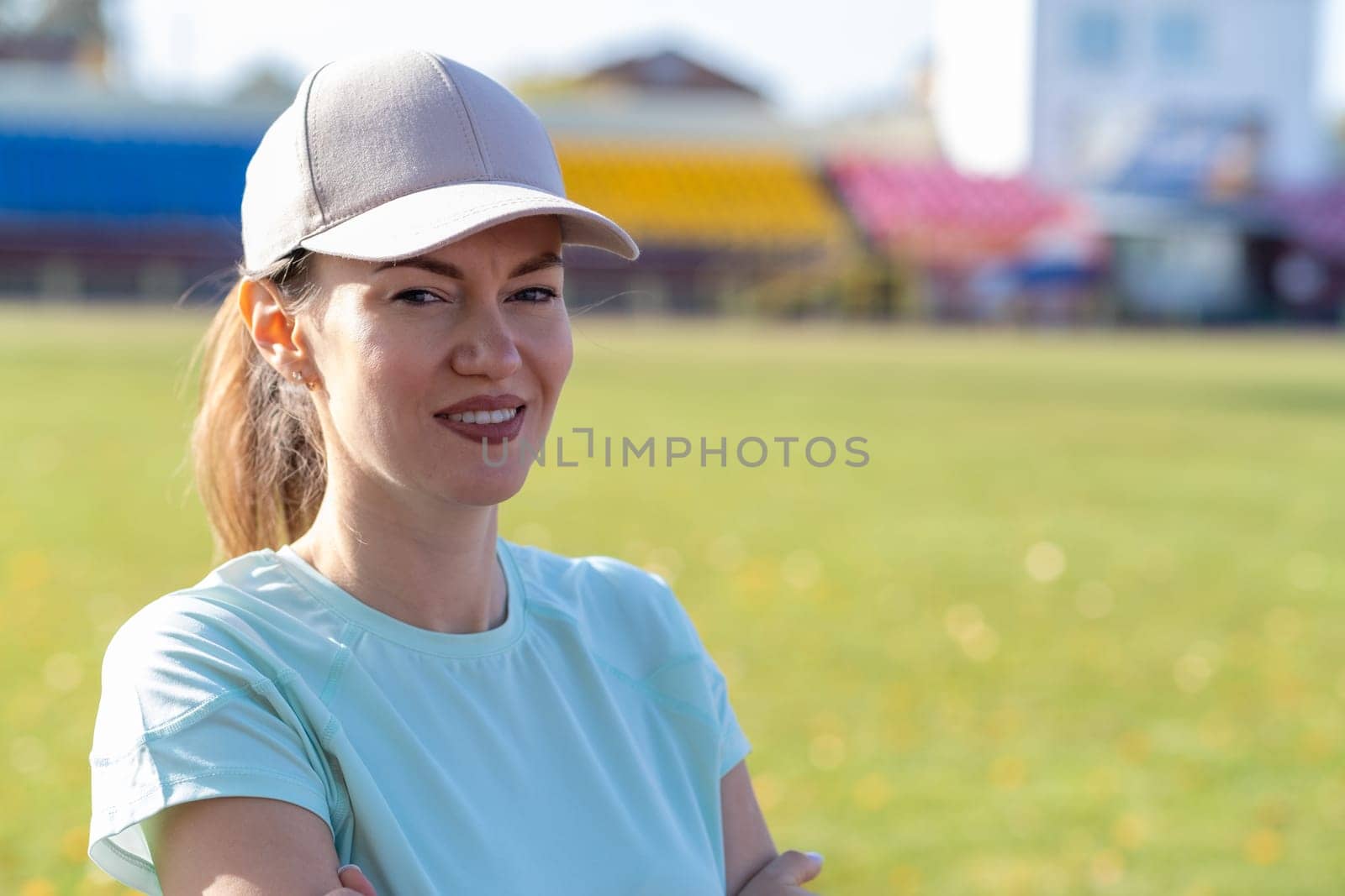 A young beautiful woman in sportswear plays sports at a local stadium by AnatoliiFoto