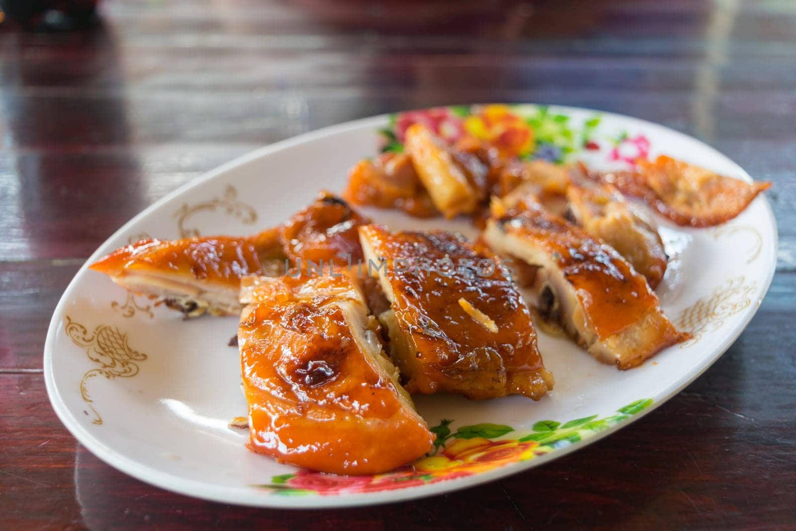 Grilled chicken in dish on wood table
