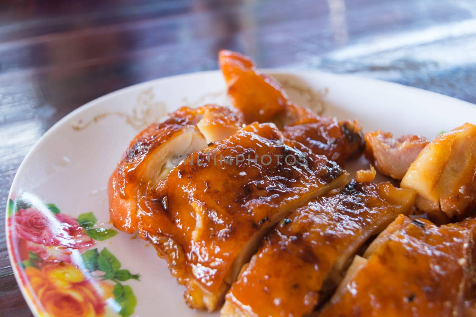Grilled chicken in dish on wood table