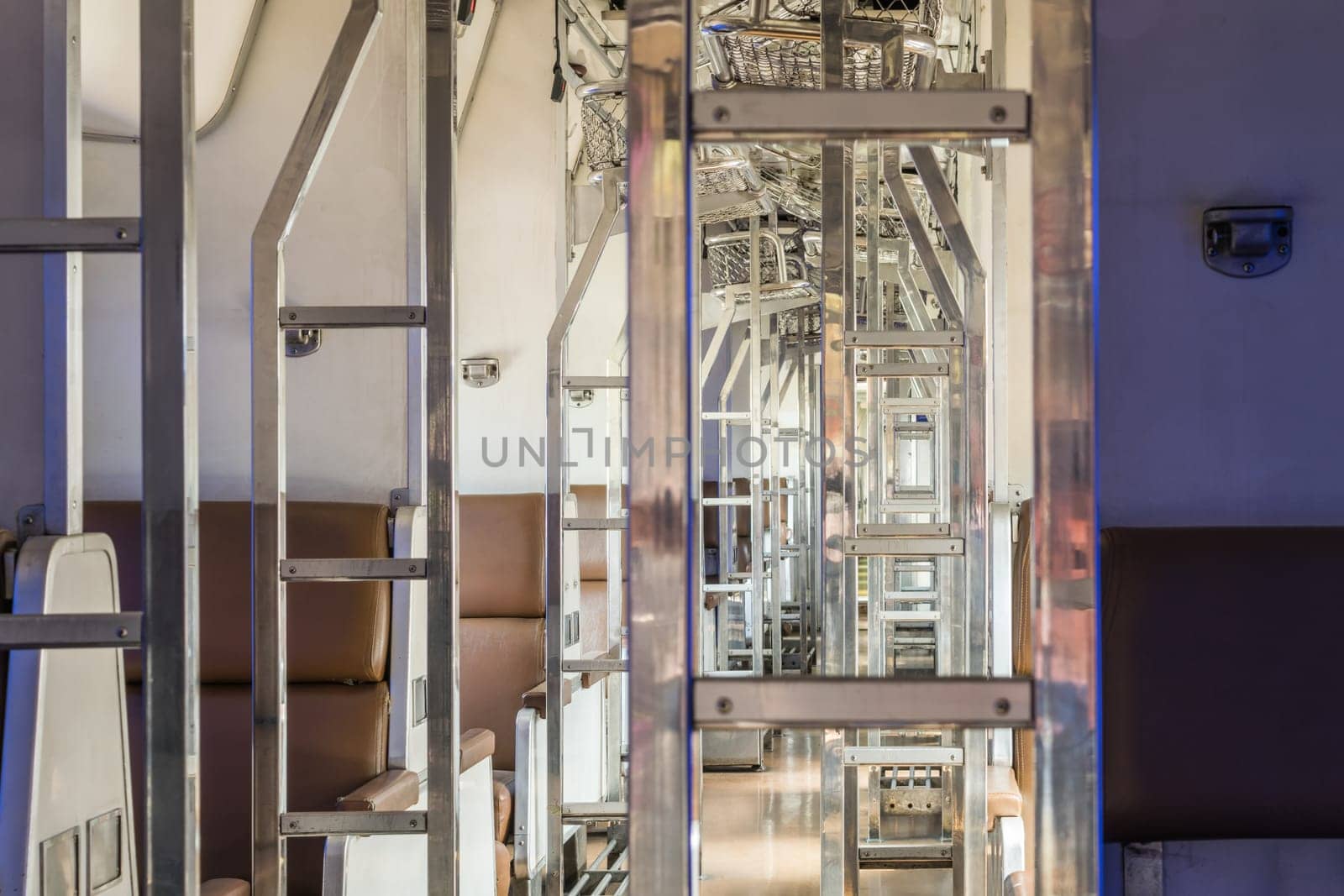 Inside of old public Thai railway train cabin with seats, handrails, fan and interior in vintage style service for passenger transport