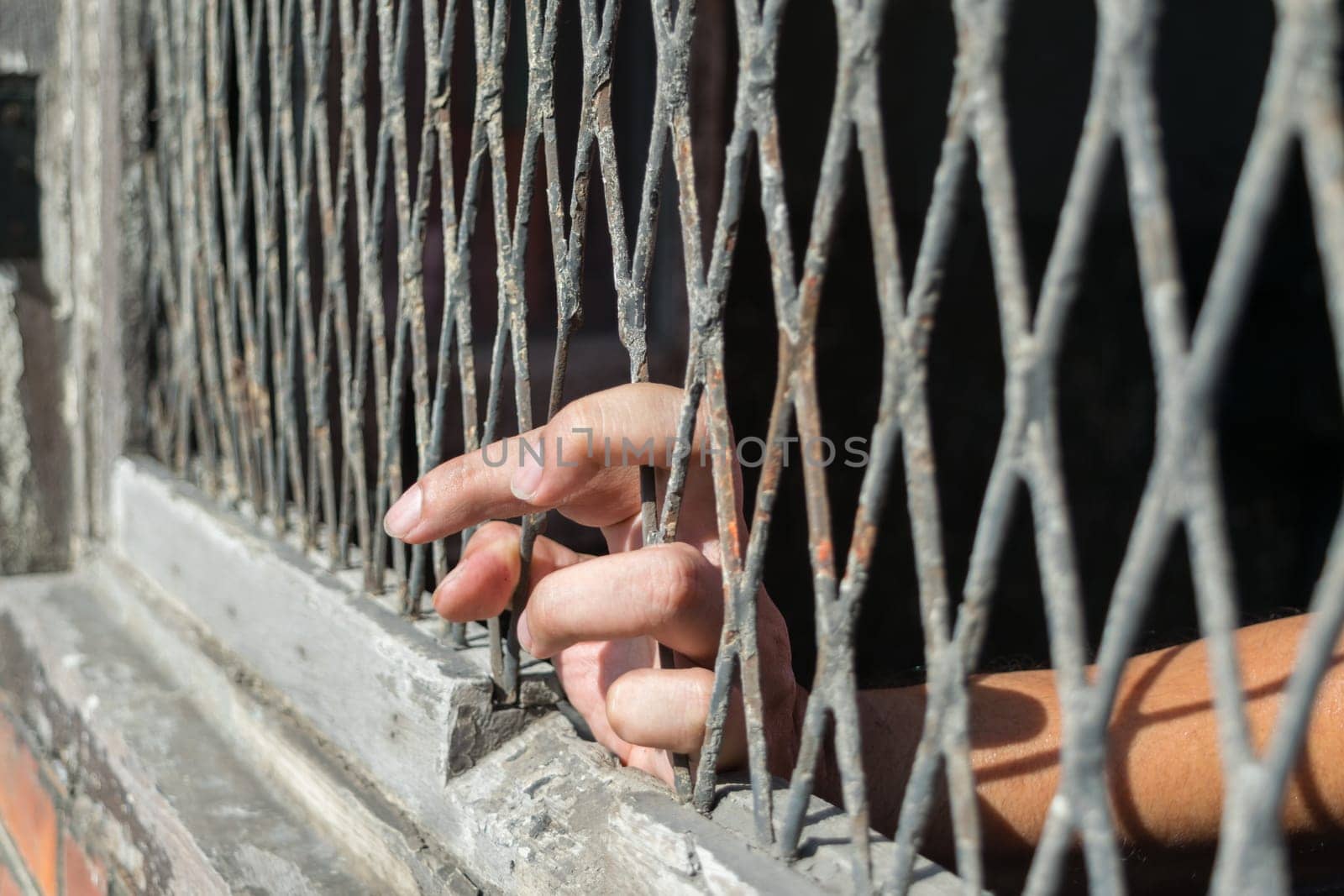 Hands of the woman on a steel lattice close up