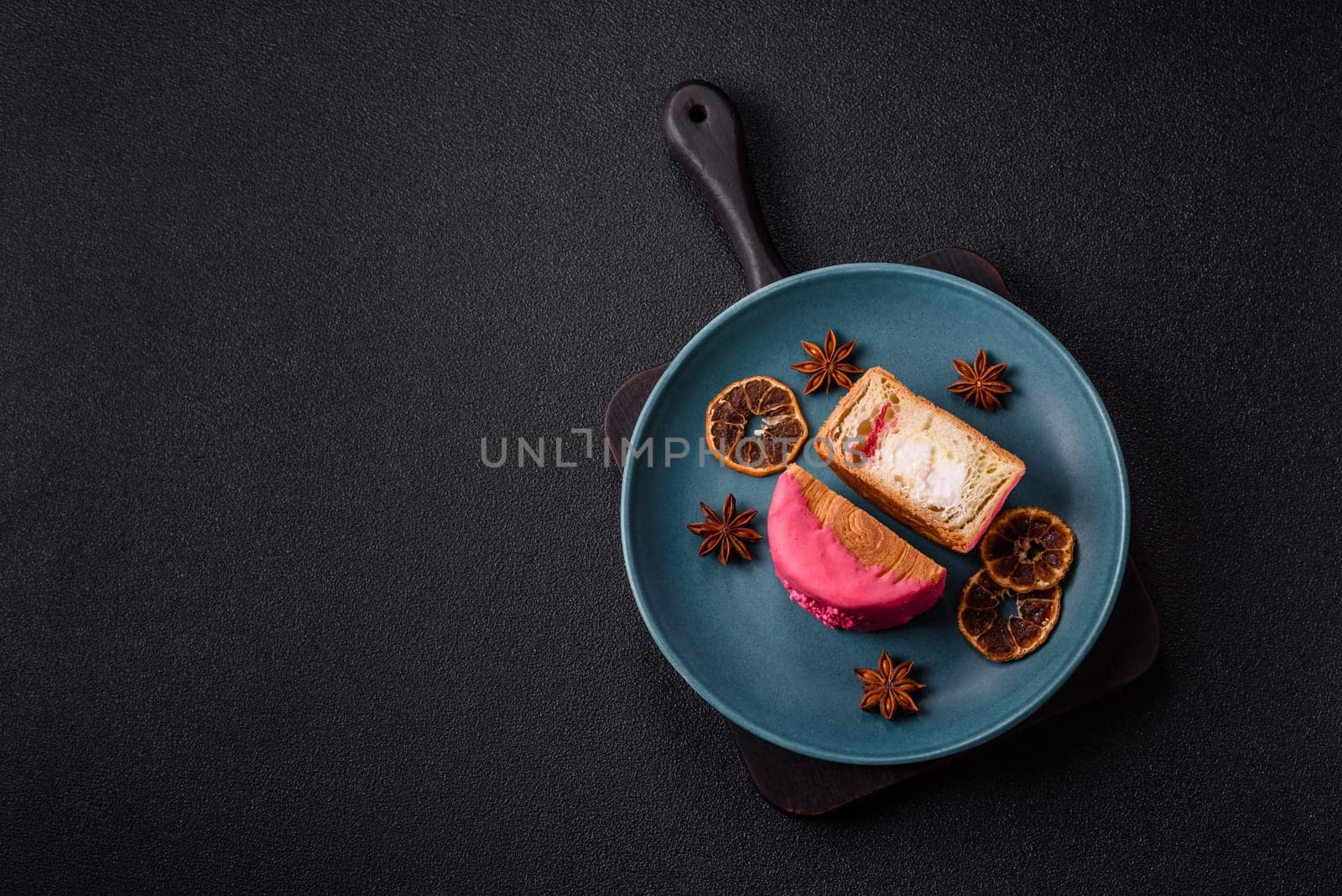 Round sweet New York roll croissant with raspberry cream filling on a dark concrete background